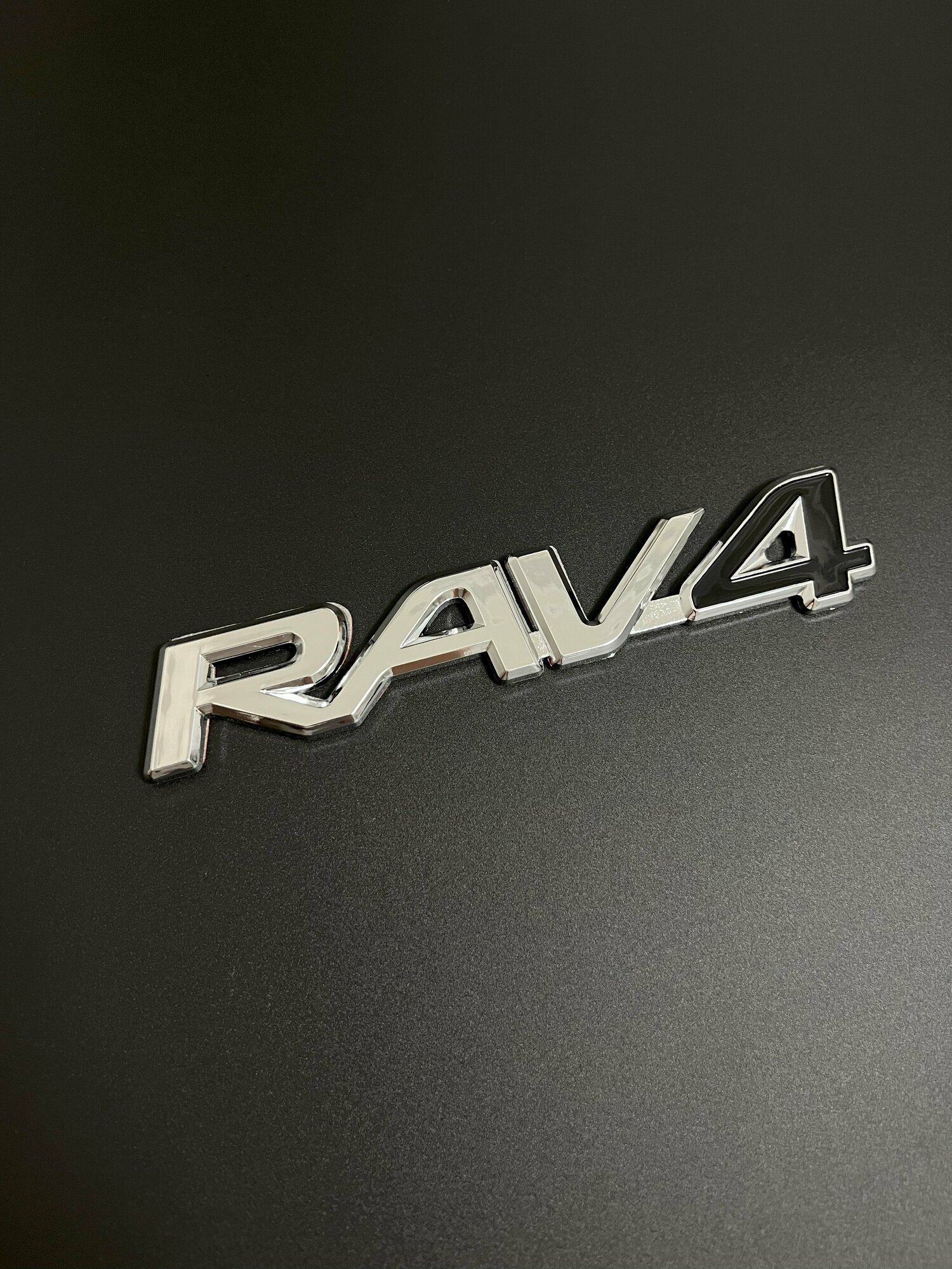 Шильдик RAV4 черный на багажник автомобиля