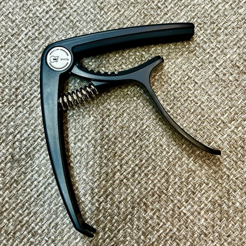 Каподастр для акустической и электрогитары Rockzz RKZBDJ-56 черный, пружинный механизм, алюминий