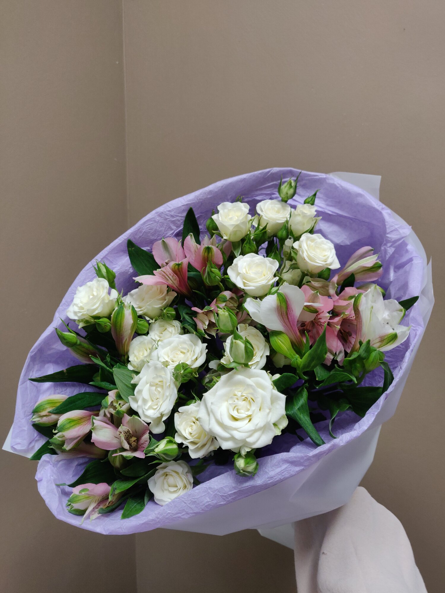 Букет белых кустовых роз и альстромерии в эффектной круглой упаковке.