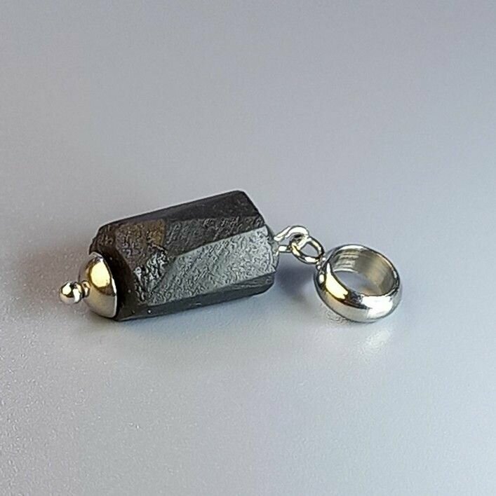 чёрный турмалин и серебряная подвеска рядом с гитарой