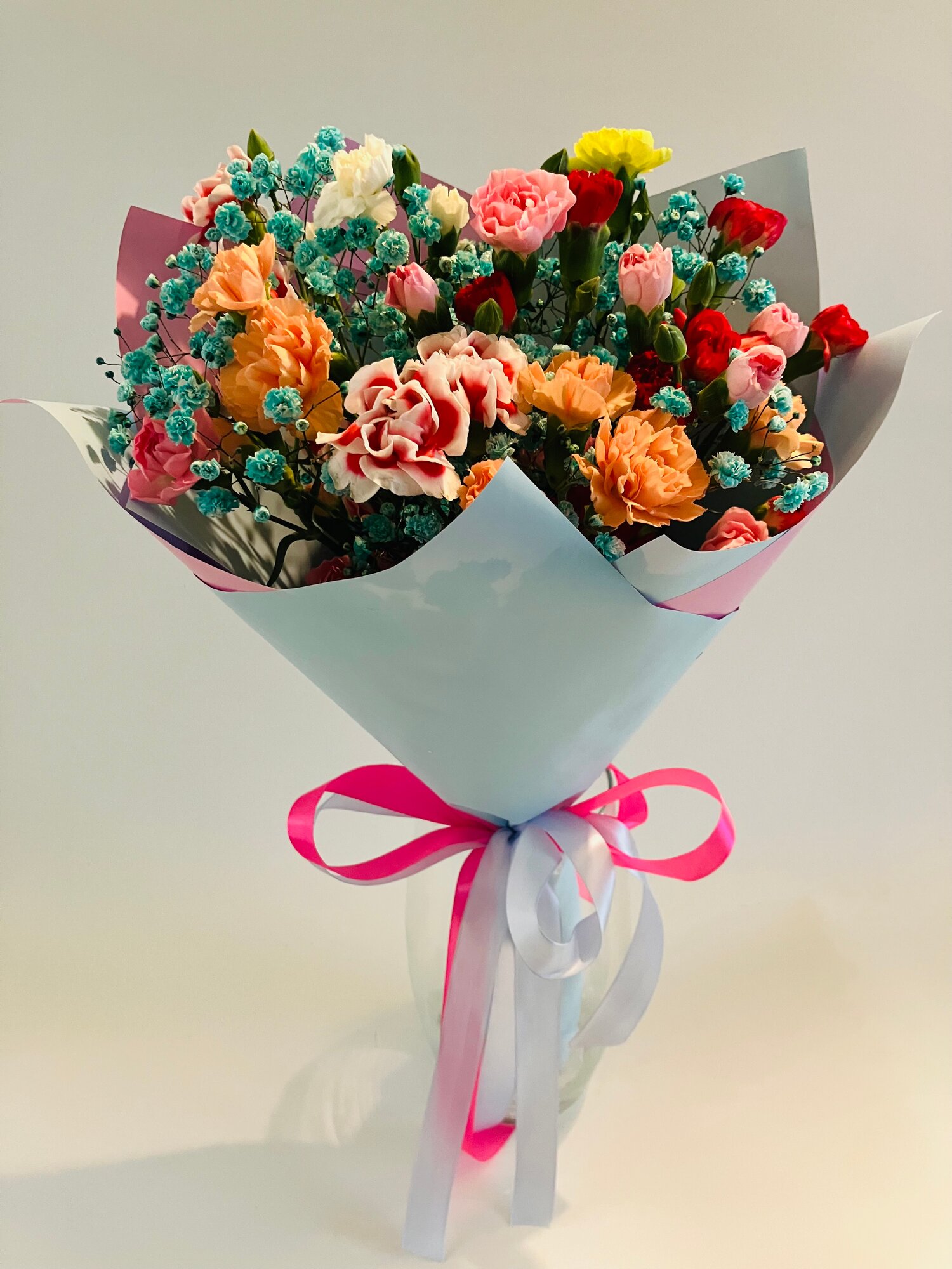 Букет из 11 кустовых гвоздик микс с голубой гипсофилой 55 см+ в дизайнерской упаковке атласный бант.