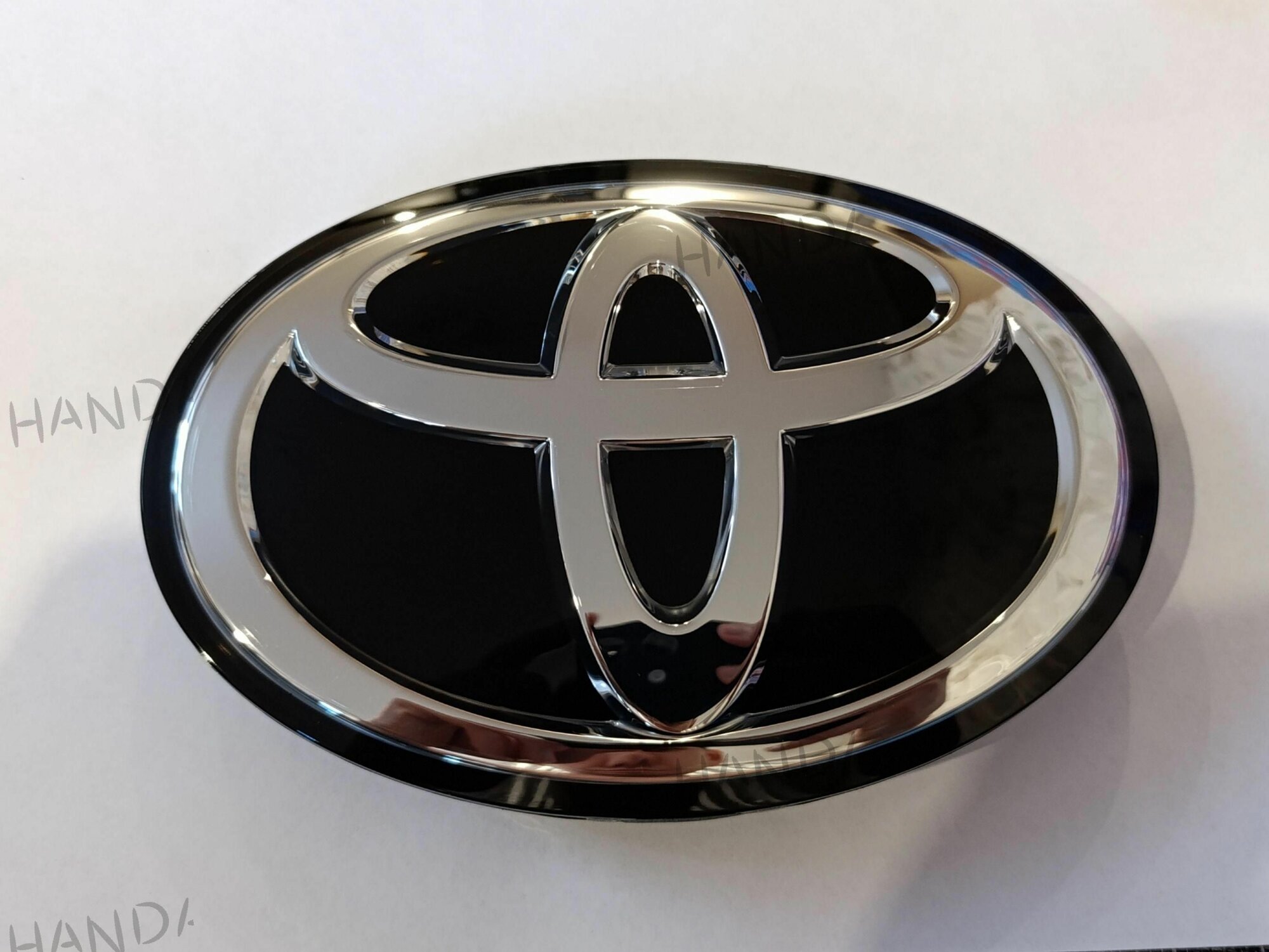 Эмблема Toyota передняя, черная, 19х13 см, Land Cruiser 200/Prado/Fortuner, 75312-60050