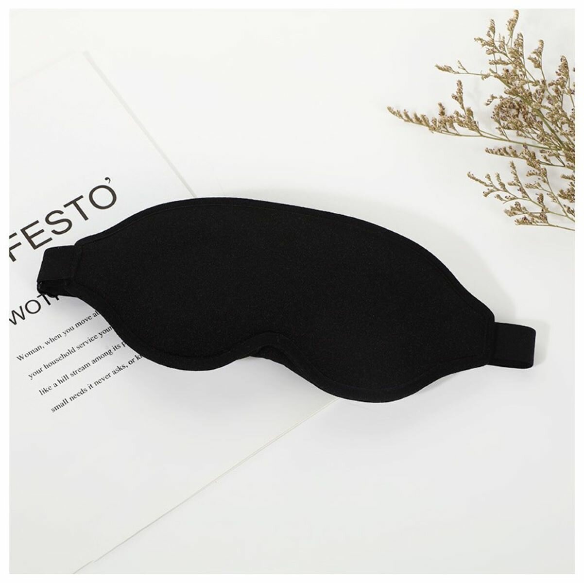 Черная матовая маска для сна в руках с этикеткой по уходу