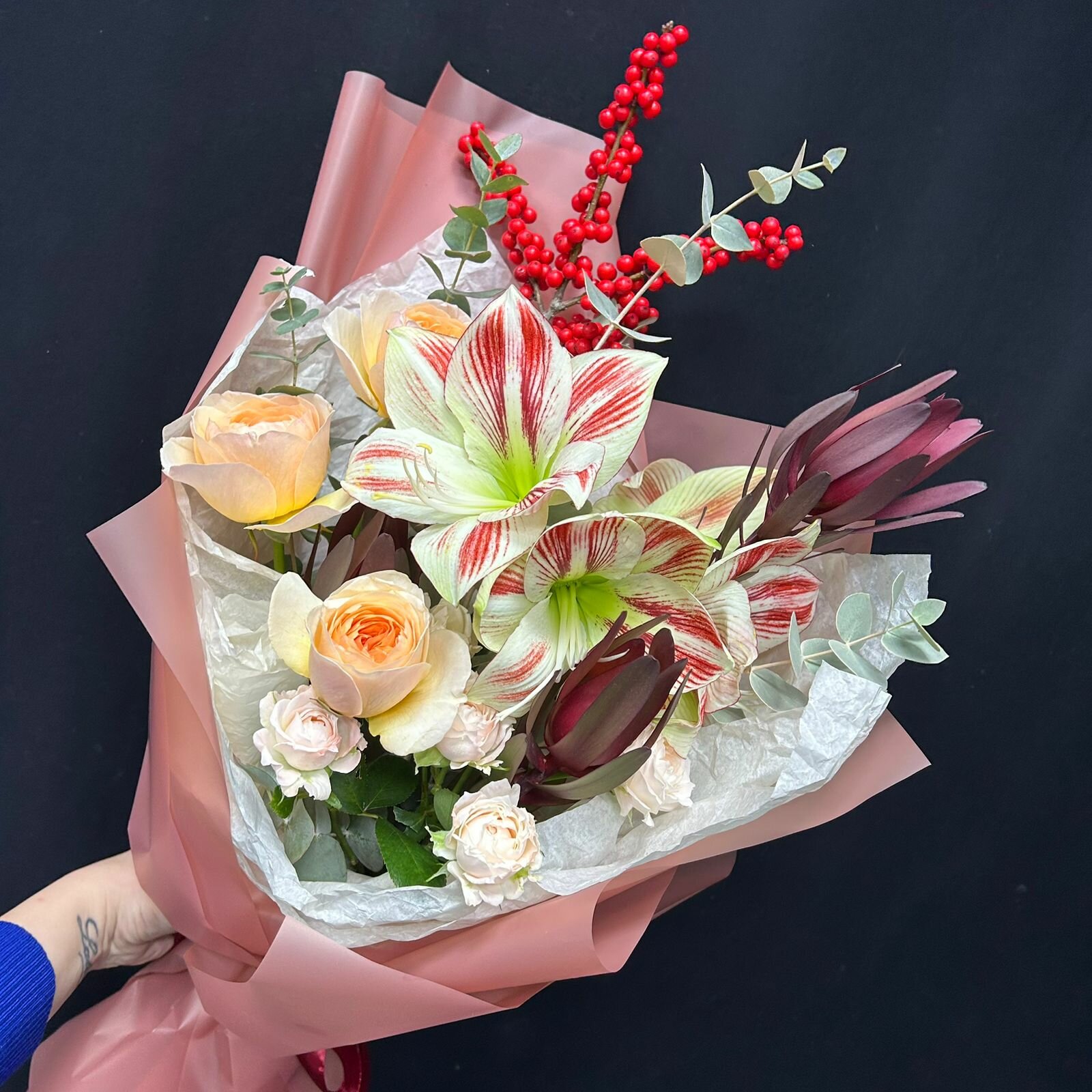 Сезонный букет с красно-белым амариллисом красным илексом и леукадендроном в авторской упаковке