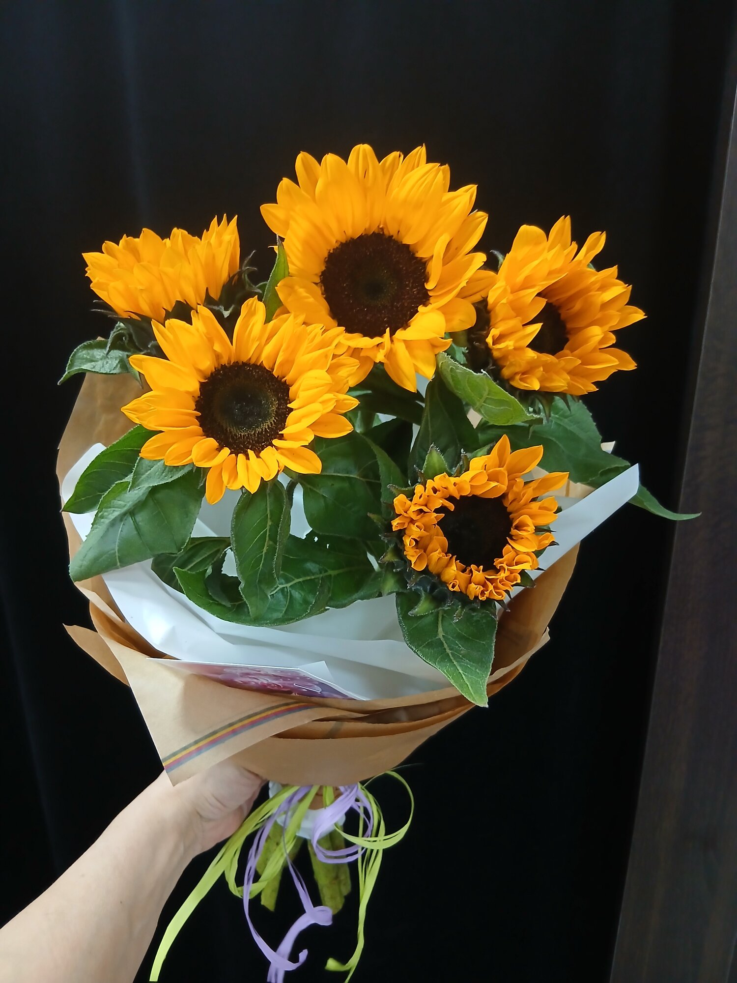Букет живых цветов из 5 ти подсолнухов в упаковке.