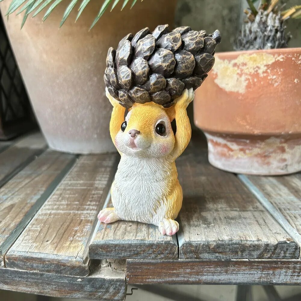 Маленькая белка с шишкой суккуленты садовый стол декоративные растения животные.