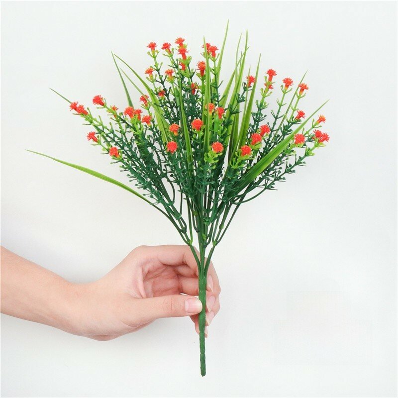 Artificial plastic grass bundle with realistic flowers for home decor and soft interior styling orange star
