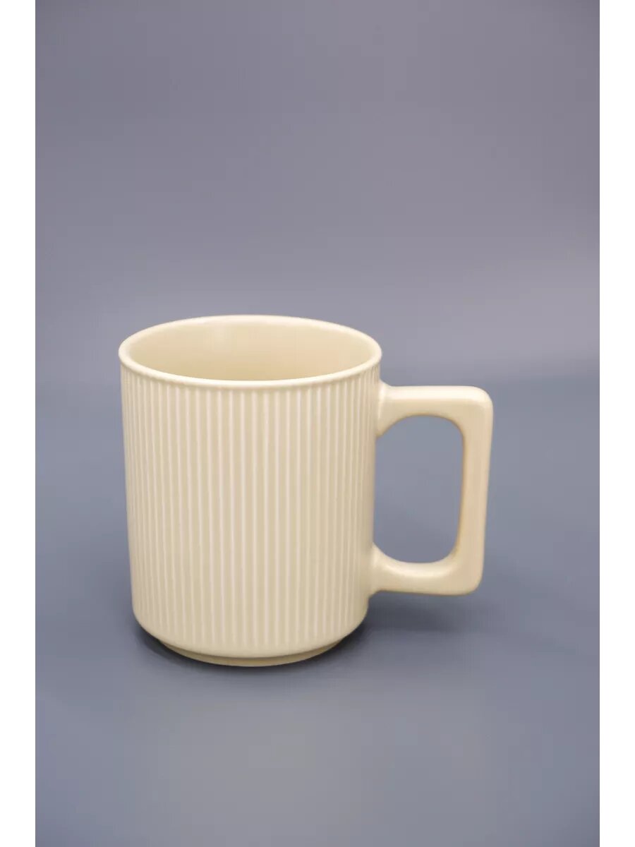 Керамическая кружка с вертикальными ребристыми линиями и квадратной ручкой.