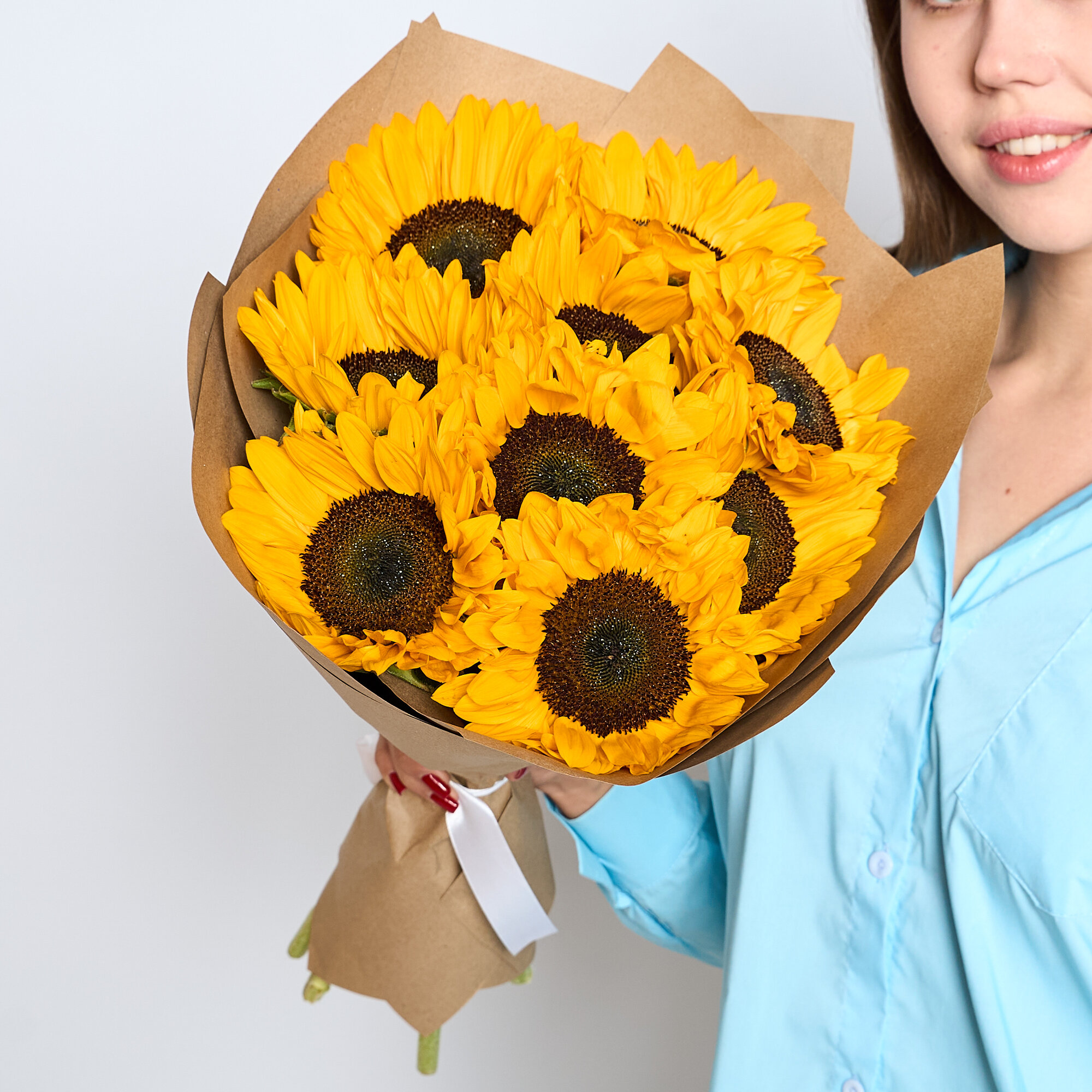 Букет из 9 ярких желтых подсолнухов собранные в крафтовой упаковке
