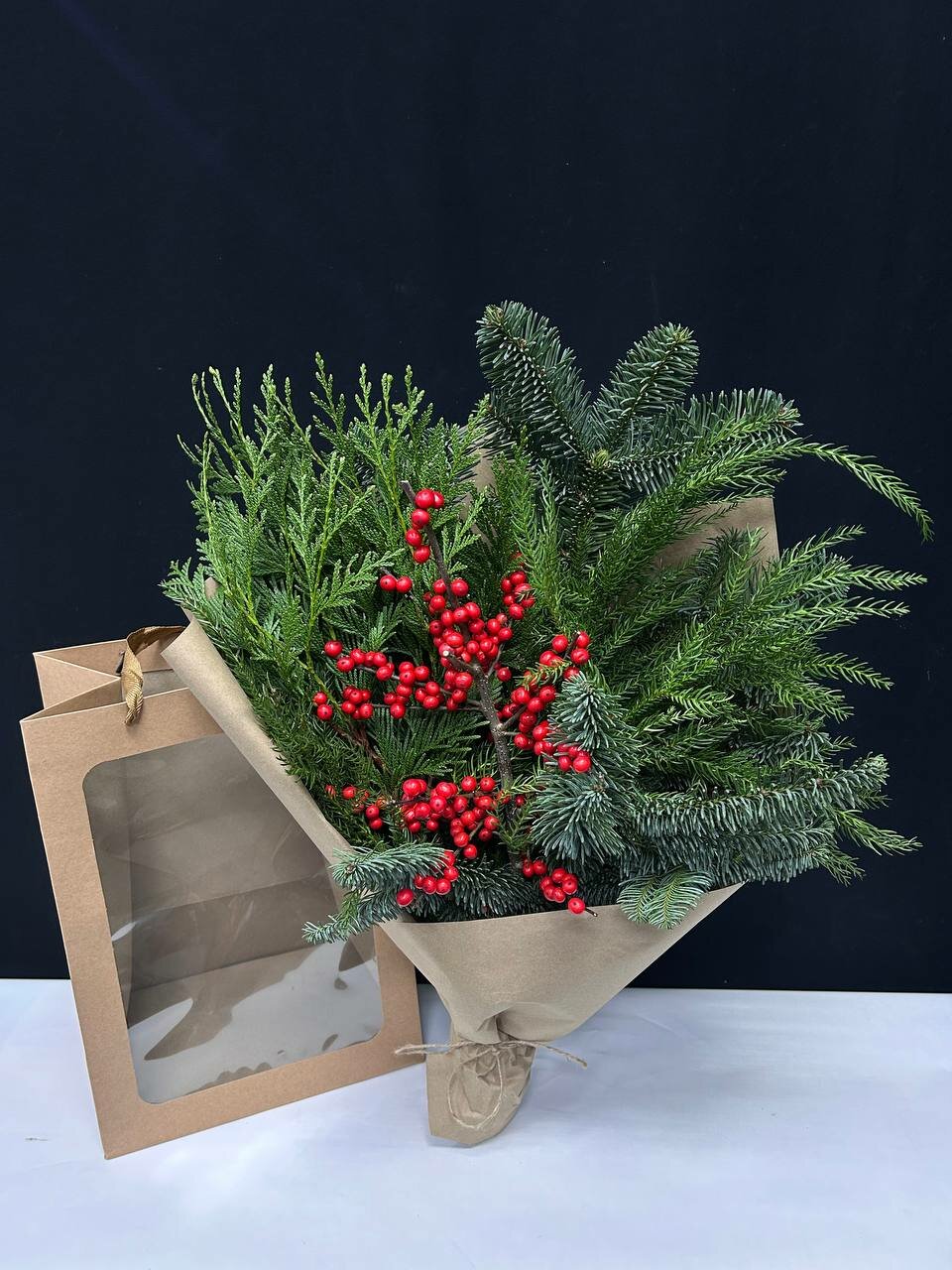 Интерьерный зимний букет с хвоей и илексом в крафтовом пакете