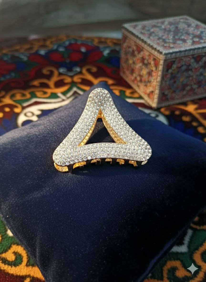 Женская заколка для волос с металлическими элементами и стразами.