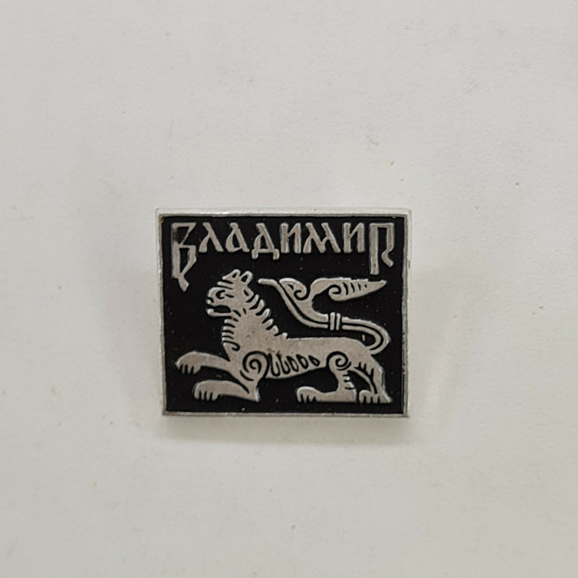 Владимир. Лев и птица на черном фоне. Винтажный значек.