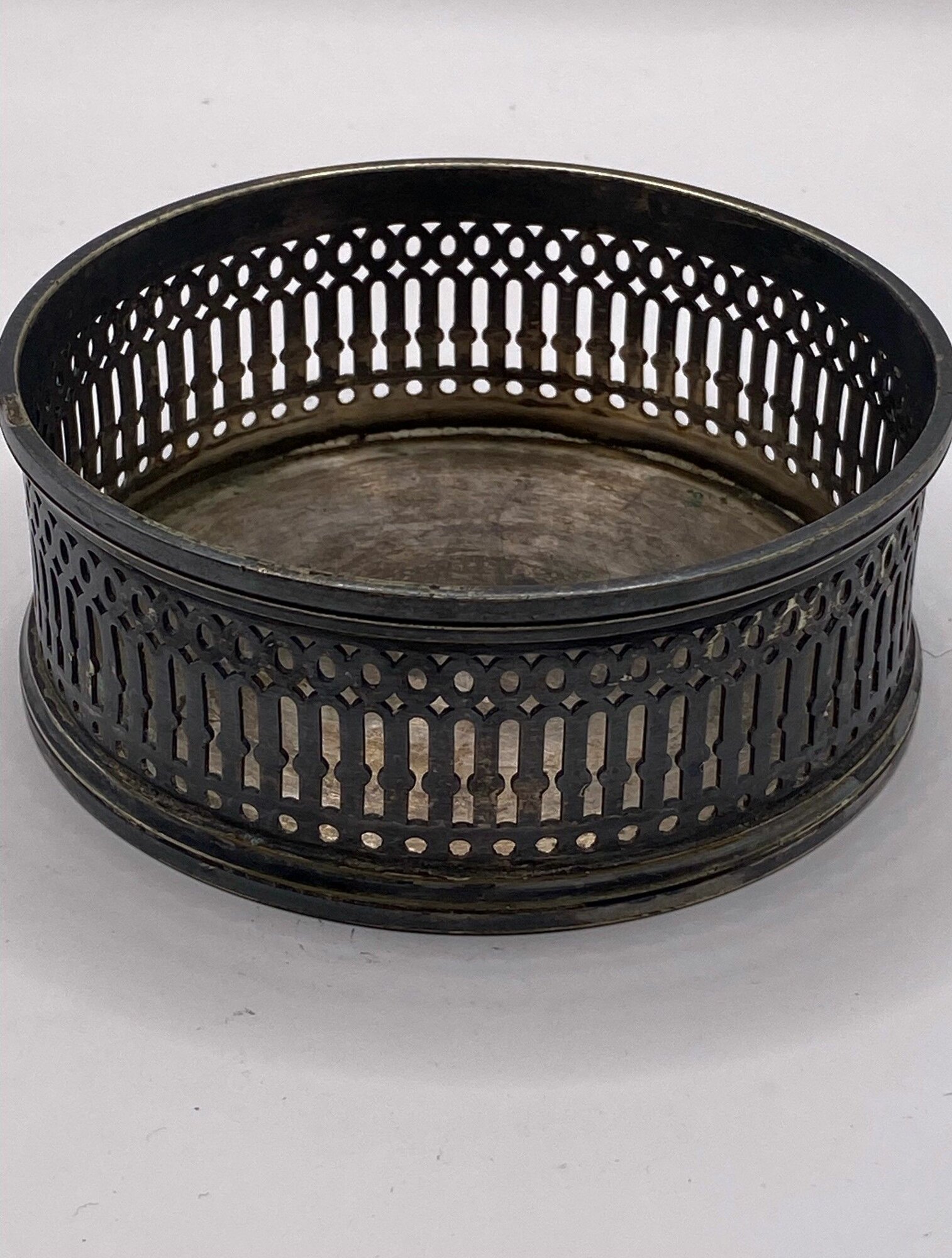 Подставка под бутылку. Александр Кач. Мельхиор с серебрением. Диаметр: 10.5 см. Высота: 4 см. Подставка круглой формы, прорезной.