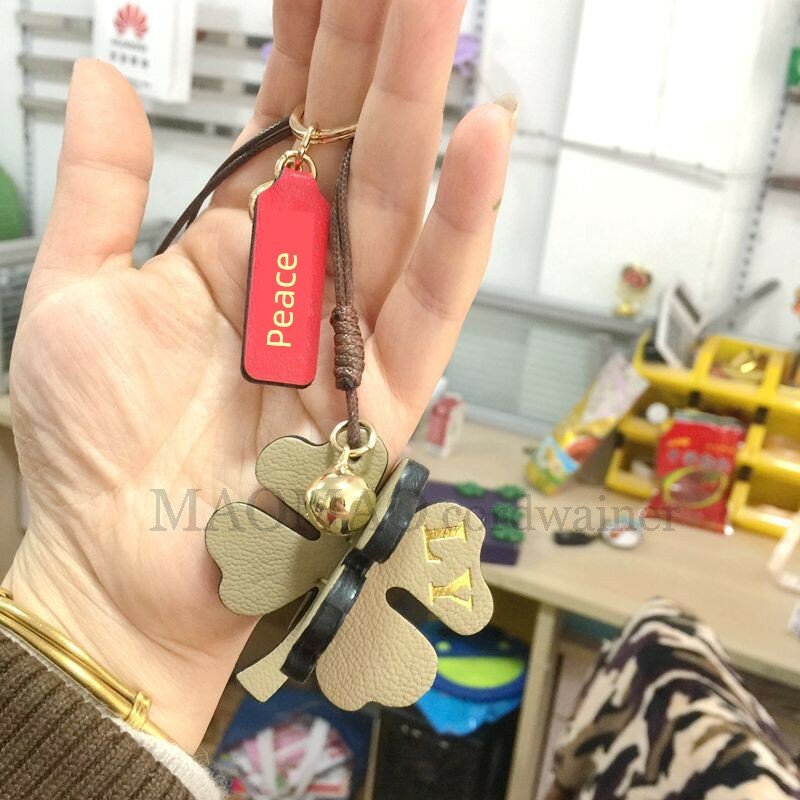 Серо-зеленый кожаный ключен с четырехлистным клевером и мирным символом