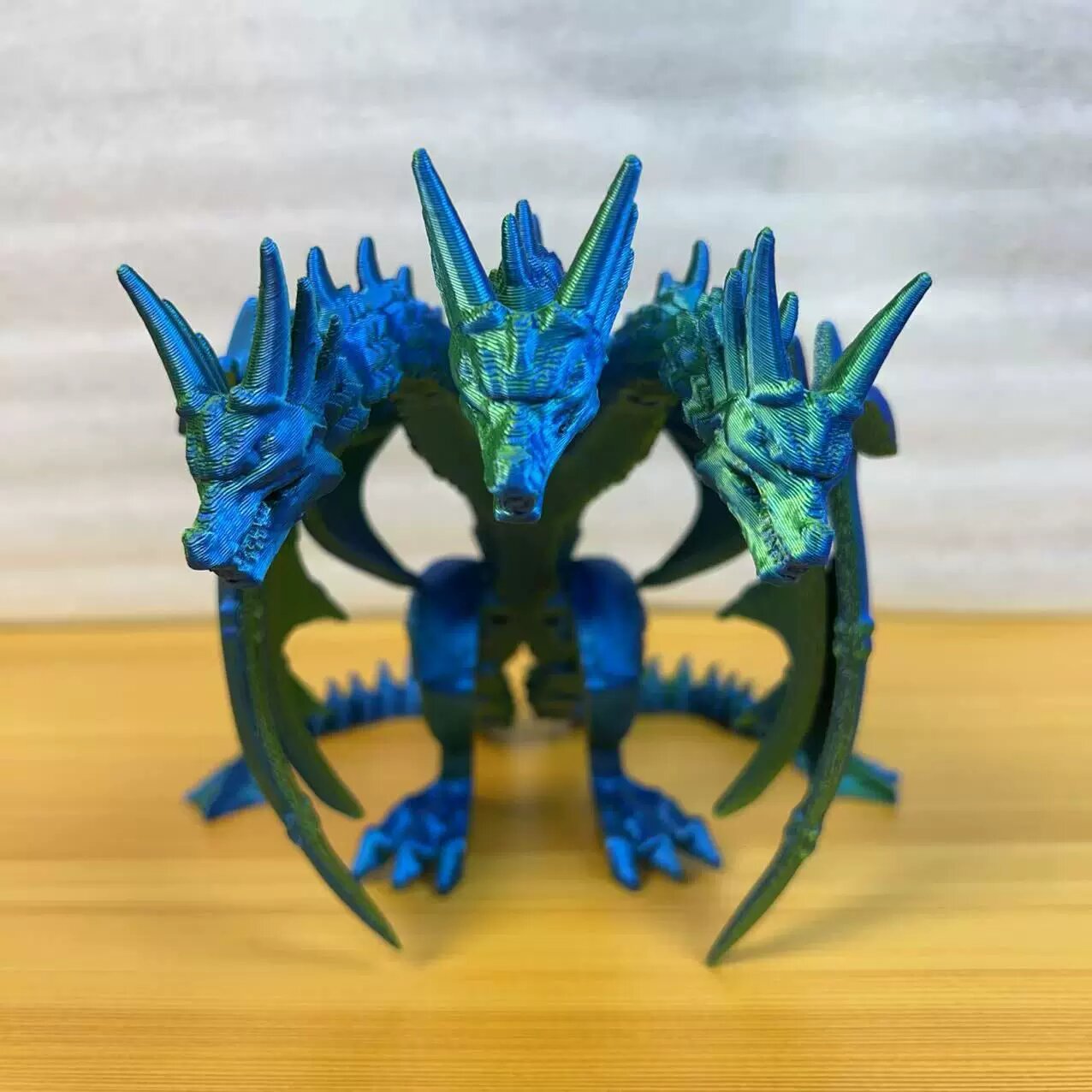 3D-печатная модель трехголового динозавра с крыльями, стоячая поза, лазерный сине-зеленый градиент, высота 13 см, длина