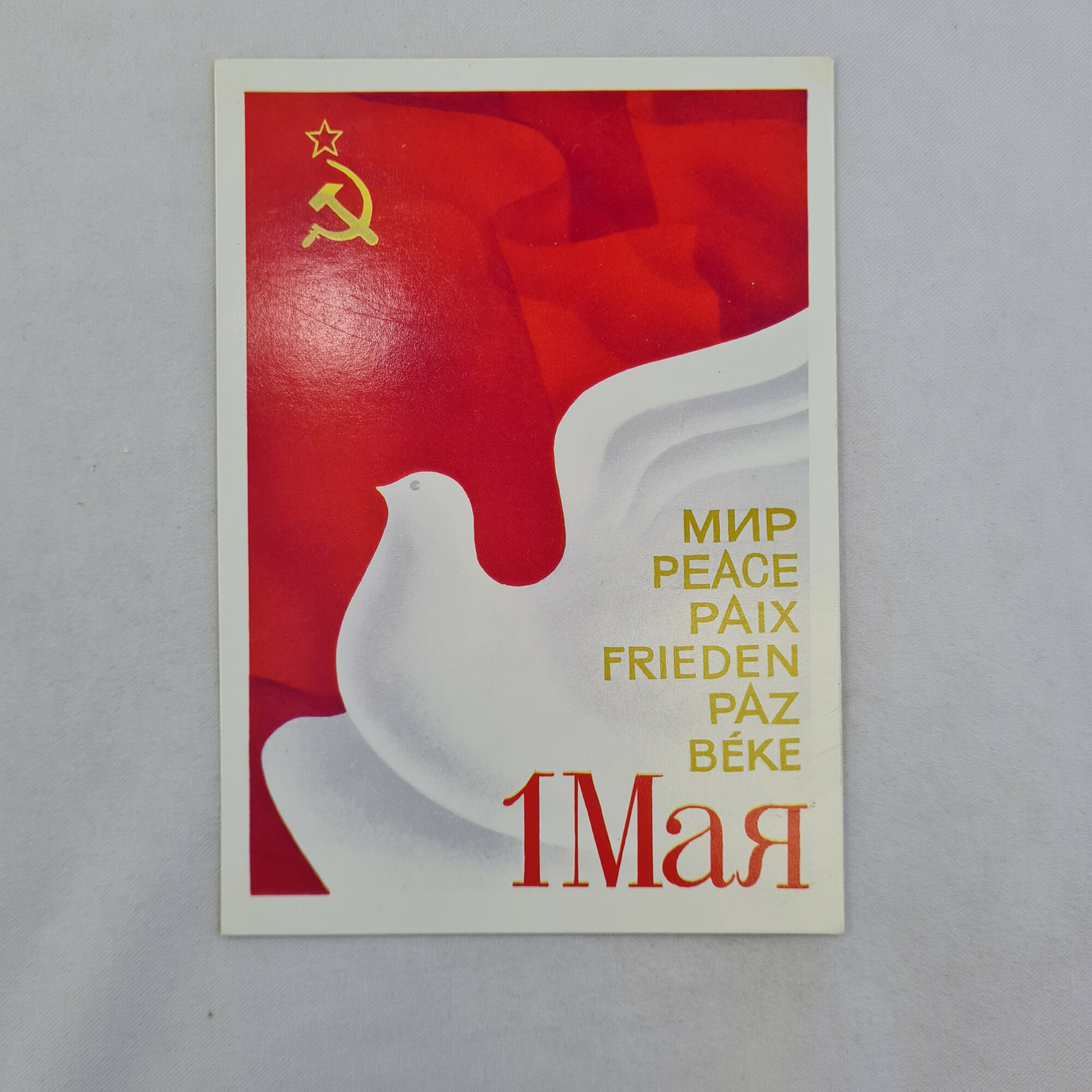 Открытка советская СССР. Голубь мира на фоне символики страны и надписей на языках мира. Винтаж