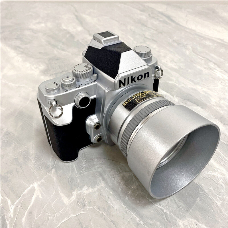 Серебристая модель фотоаппарата DSLR с объективом-крышкой для студии или декора