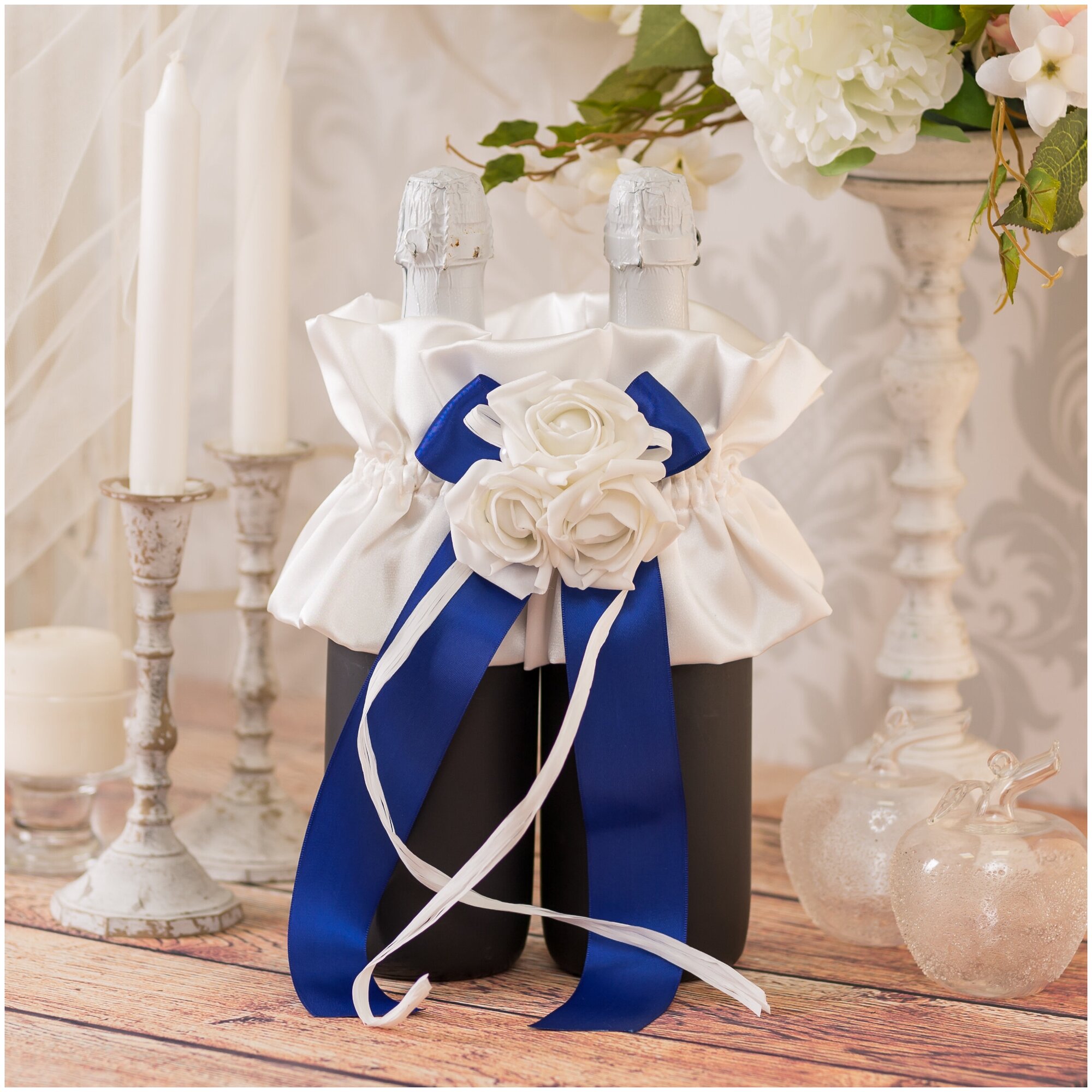 Украшение для бутылок шампанского на свадьбу молодоженам "Сапфир" из атласа кремового оттенка с синим бантом, латексными розами и рафией