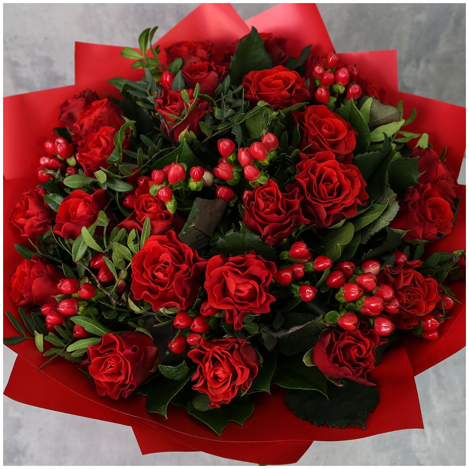 Цветы живые букет из красных роз, гиперикума в дизайнерской упаковке "Красная страсть"