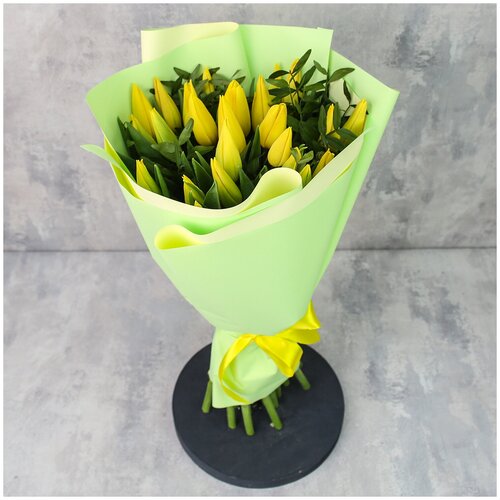 Цветы живые букет из 25 желтых тюльпанов с зеленью в дизайнерской упаковке