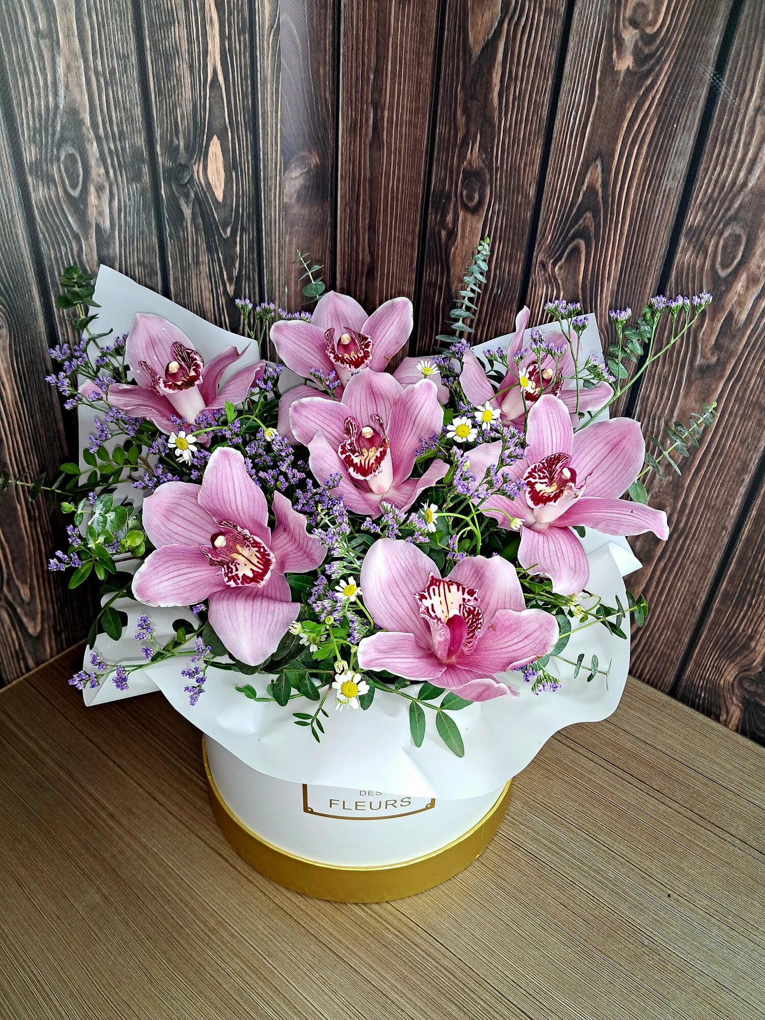 Шикарная розовая орхидея с эвкалиптом лимониумом в шляпной коробке