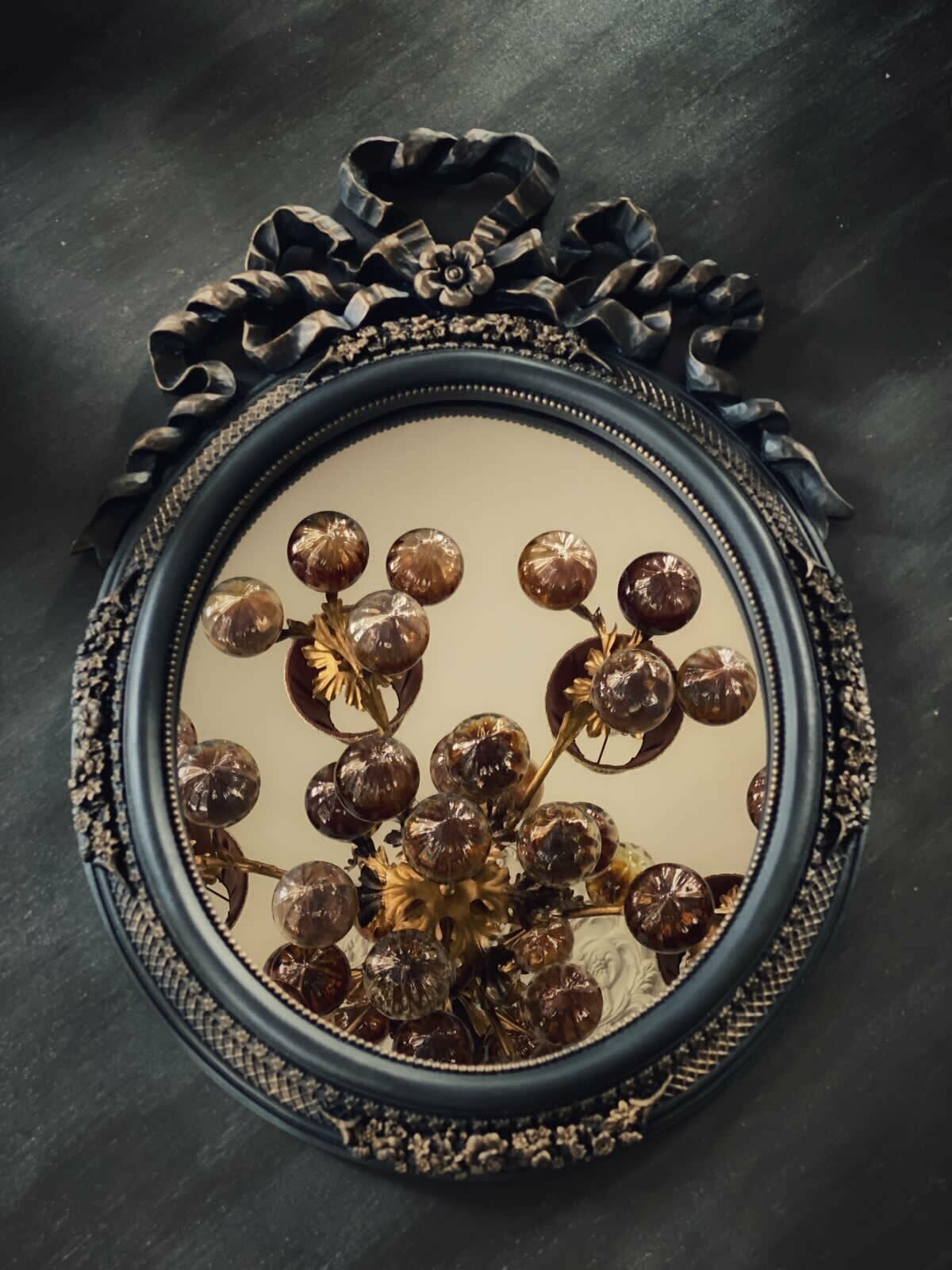 фото Интерьерное зеркало в овальной багетной раме с "бантом"