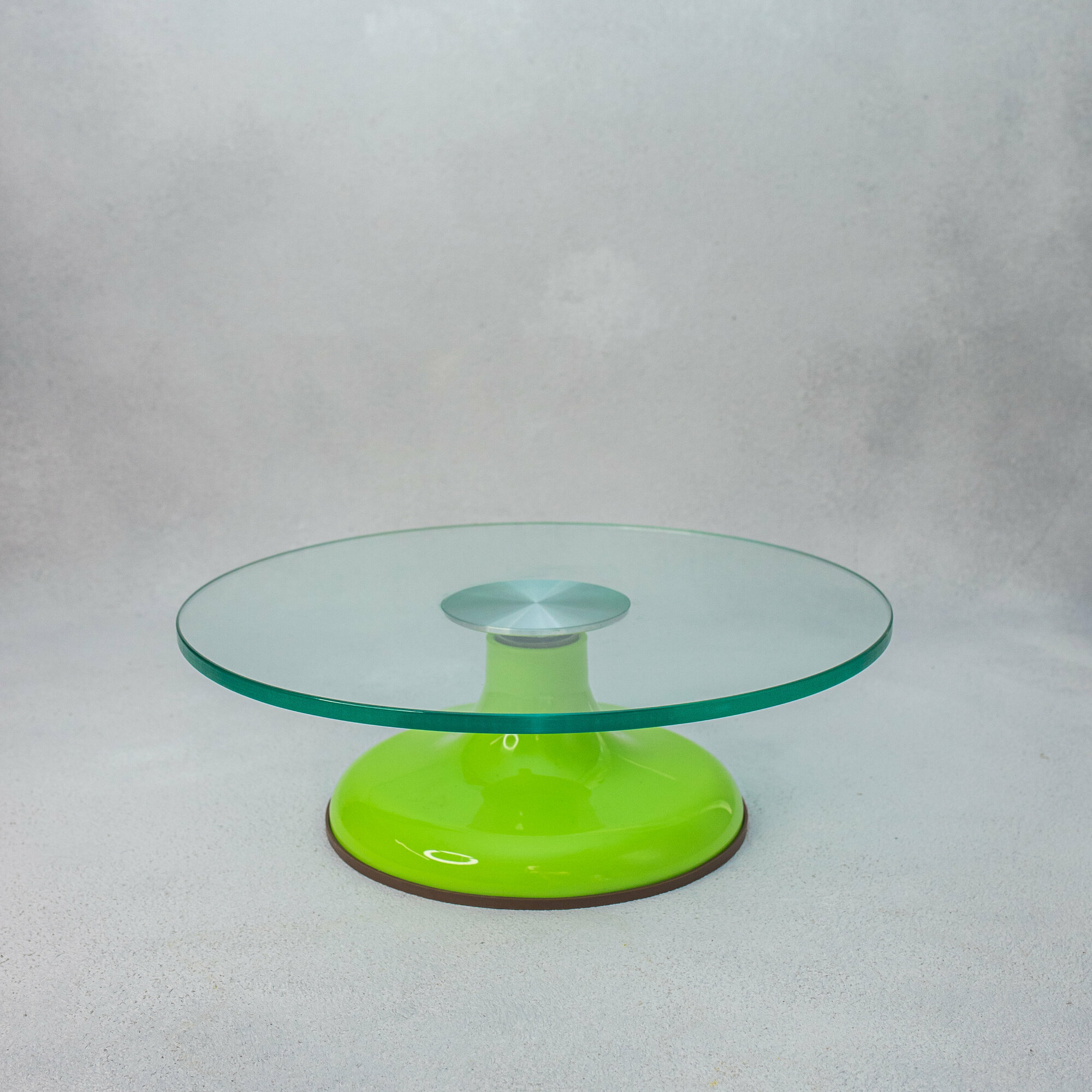 Поворотный столик с зеленой ножкой и стеклянной поверхностью