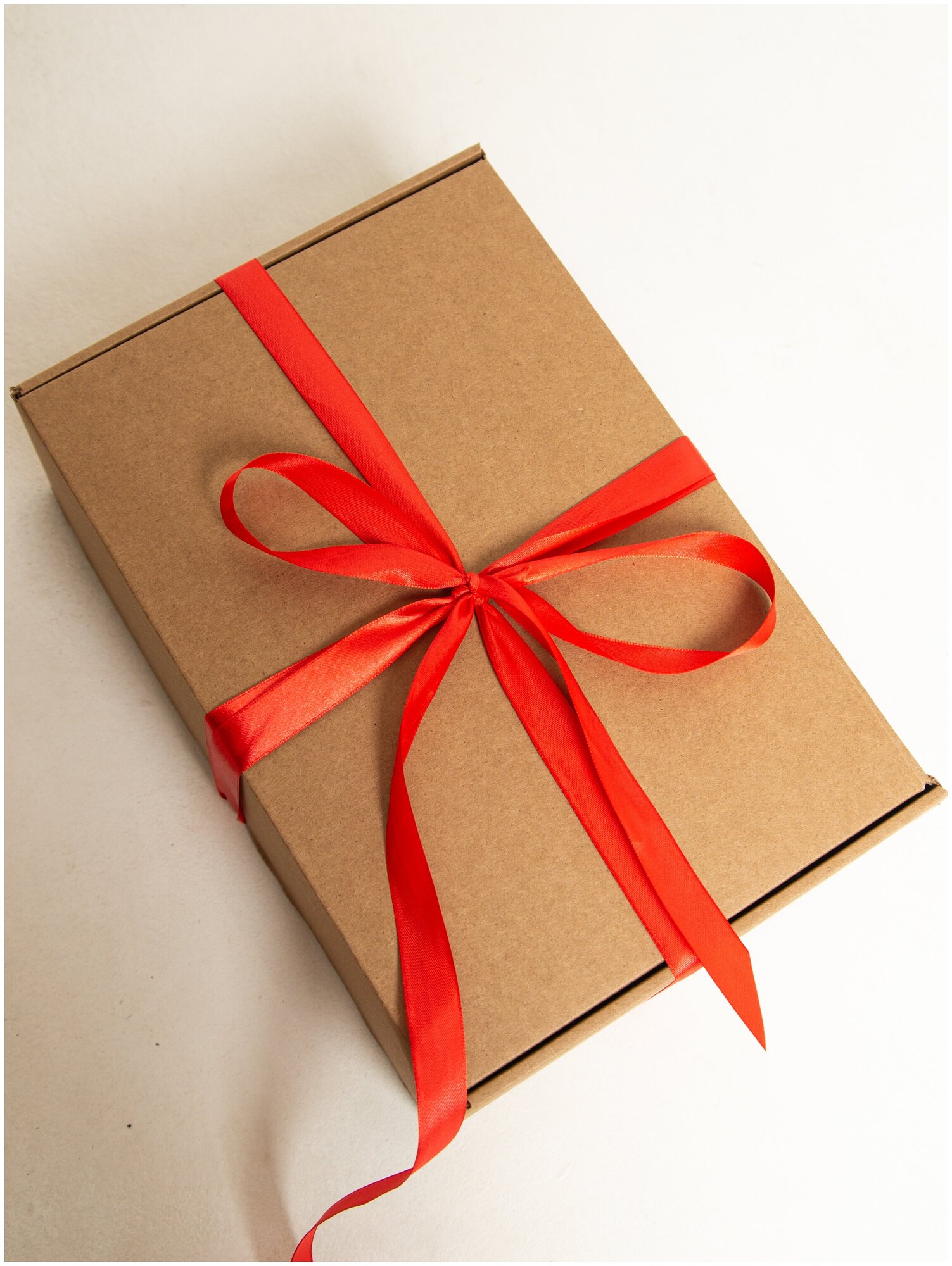 Подарочная коробка крафт с красной лентой и наполнителем 32x22x10 см