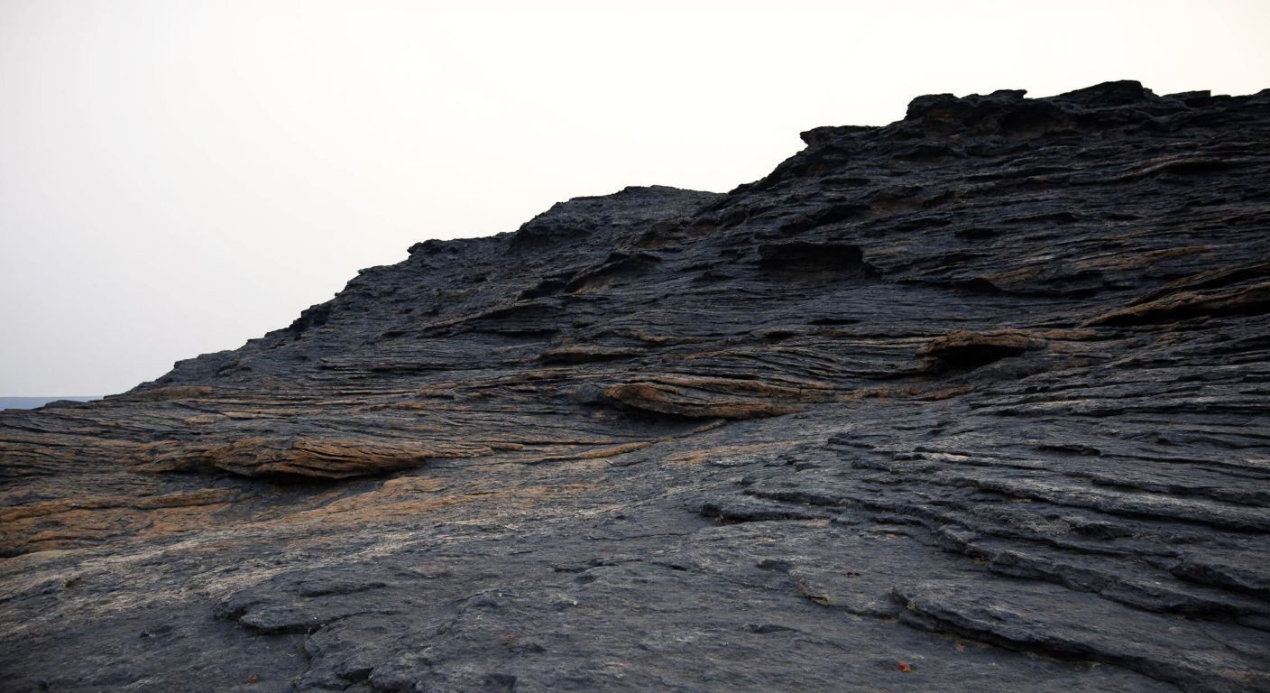 A rugged, ancient volcanic rock formation under a hazy sky, with layered stromatolite fossils embedded in its surface, evoking the vastness of deep time.