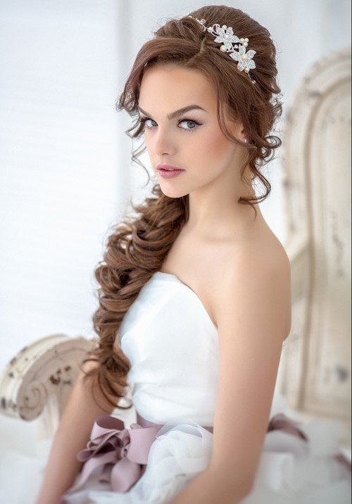 Такая прическа на длинные волосы может быть выполнена в разных вариантах и подойдет невестам с достаточно густыми волосами
