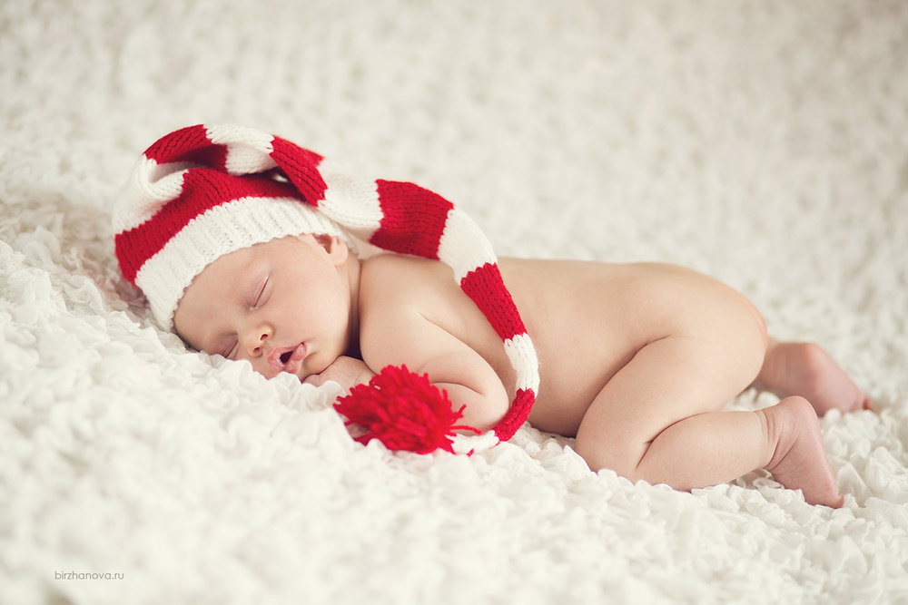 Спящий малыш в красно-белой шапочке с бубоном