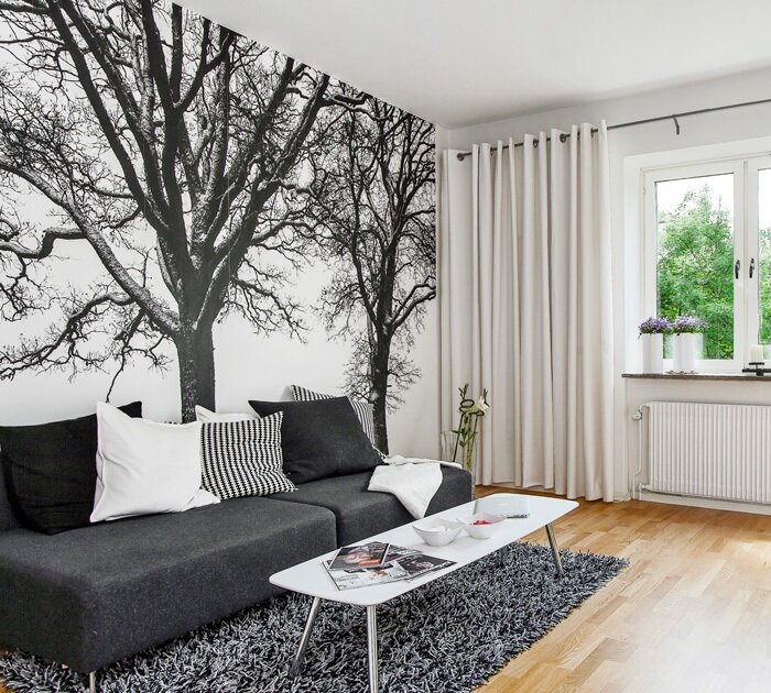 Монохромное изображение деревьев на одной из стен гостиной