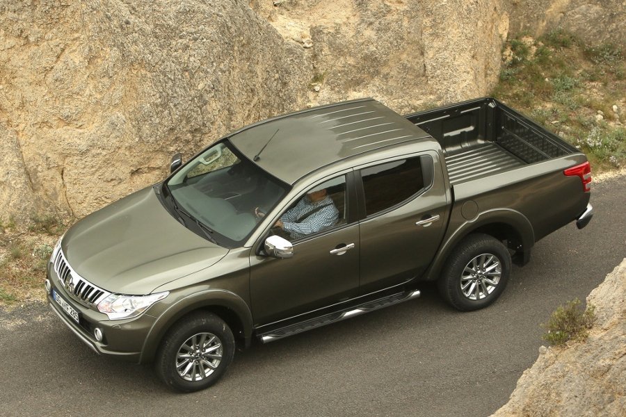 Автомобиль Mitsubishi L200 - Оливковый металлик, у подножья горы (вид спереди)