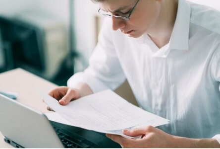 человек с ноутбуком изучает нормативные документы
