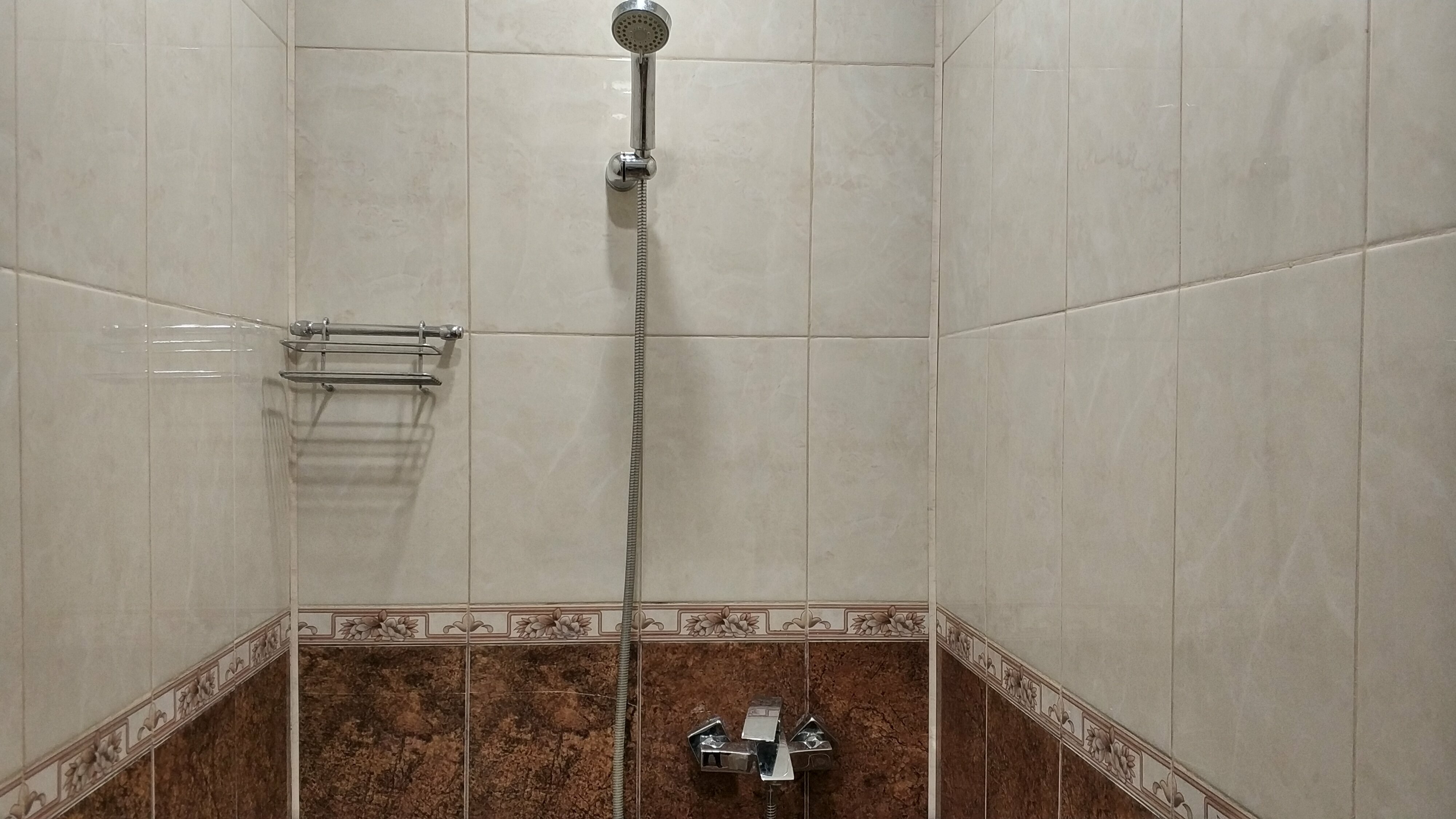 Односпальная кровать в общем номере для мужчин с общей ванной комнатой.