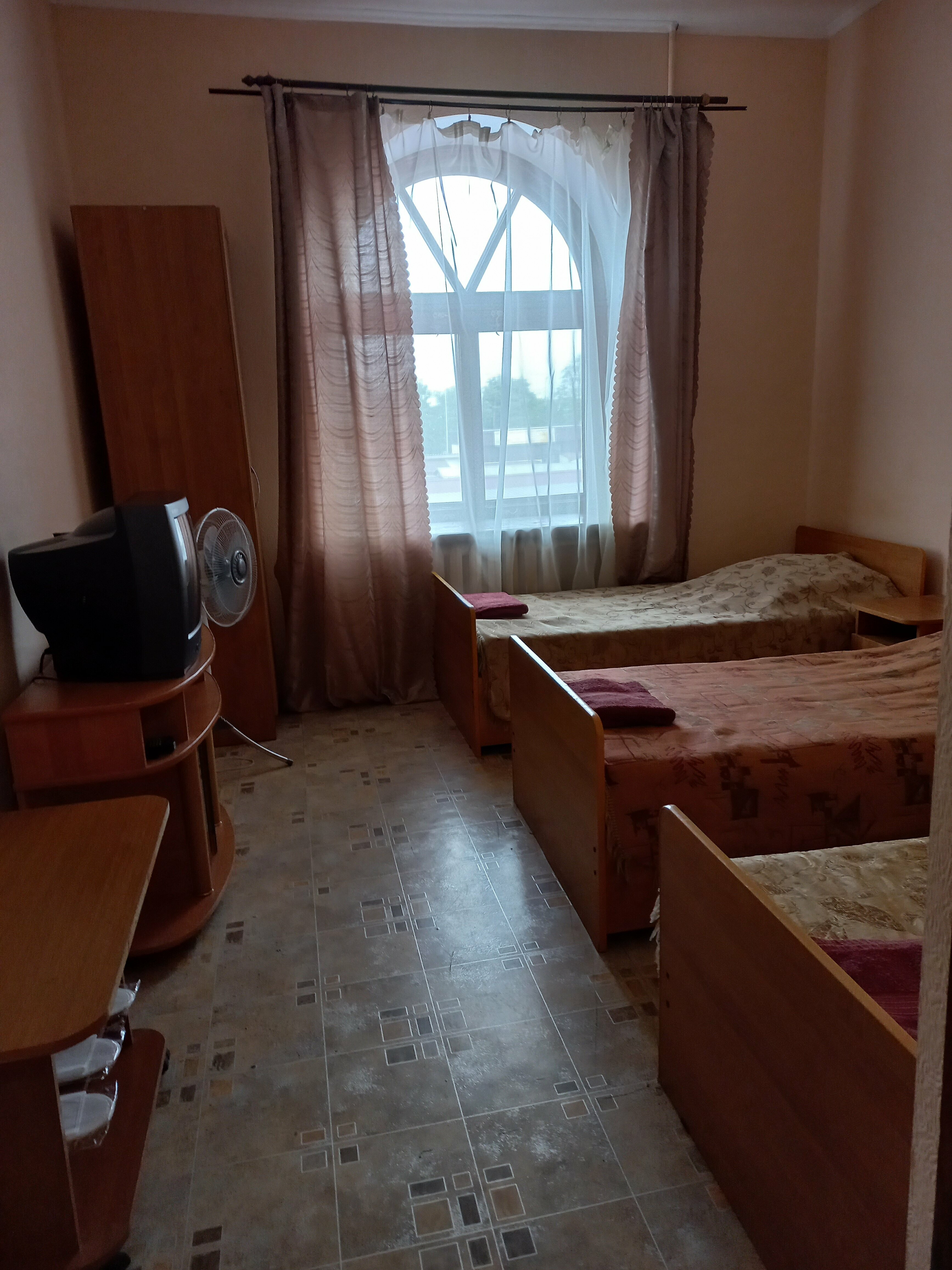 Односпальная кровать в общем номере для мужчин с общей ванной комнатой.