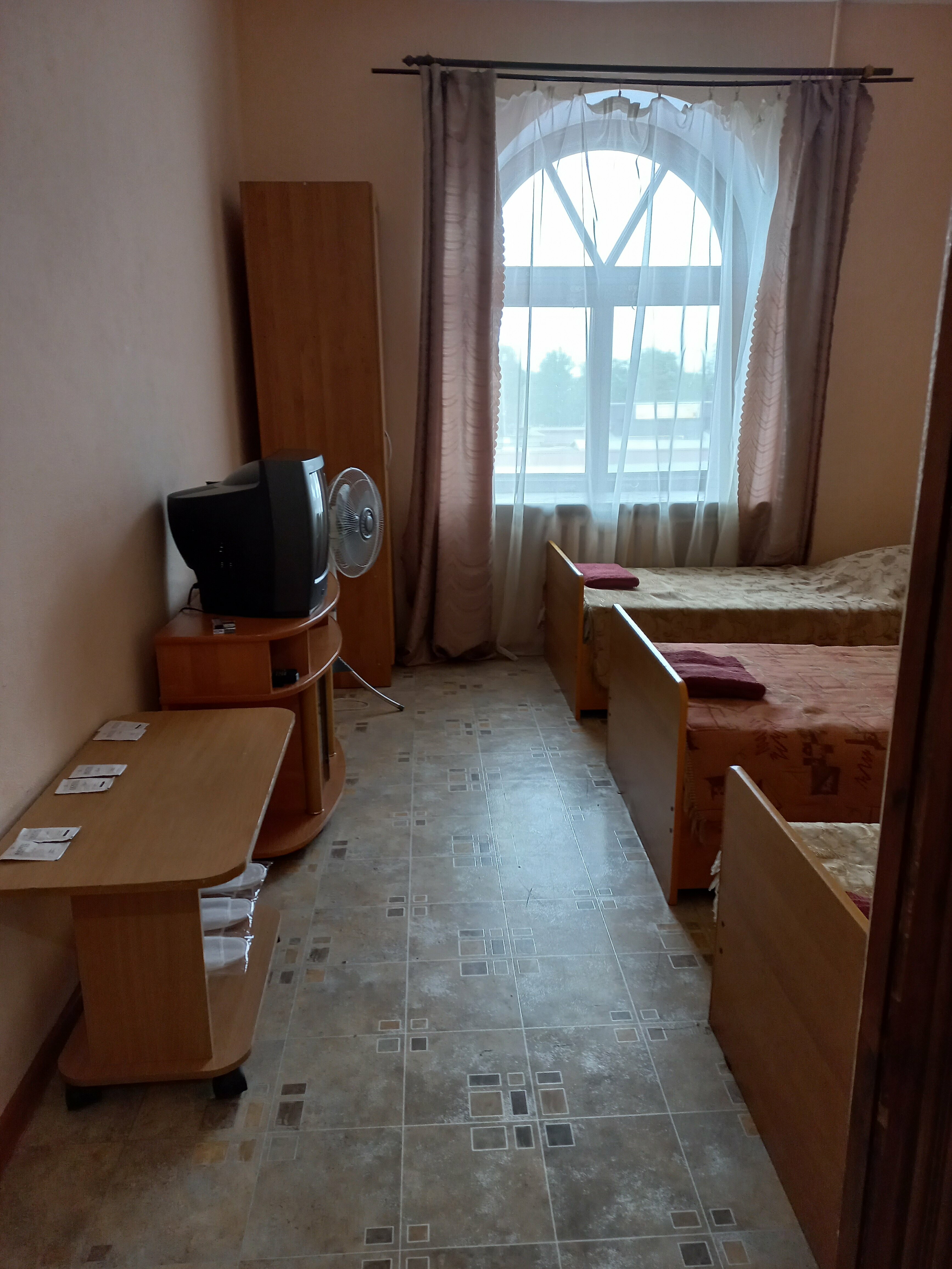 Односпальная кровать в общем номере для мужчин с общей ванной комнатой.