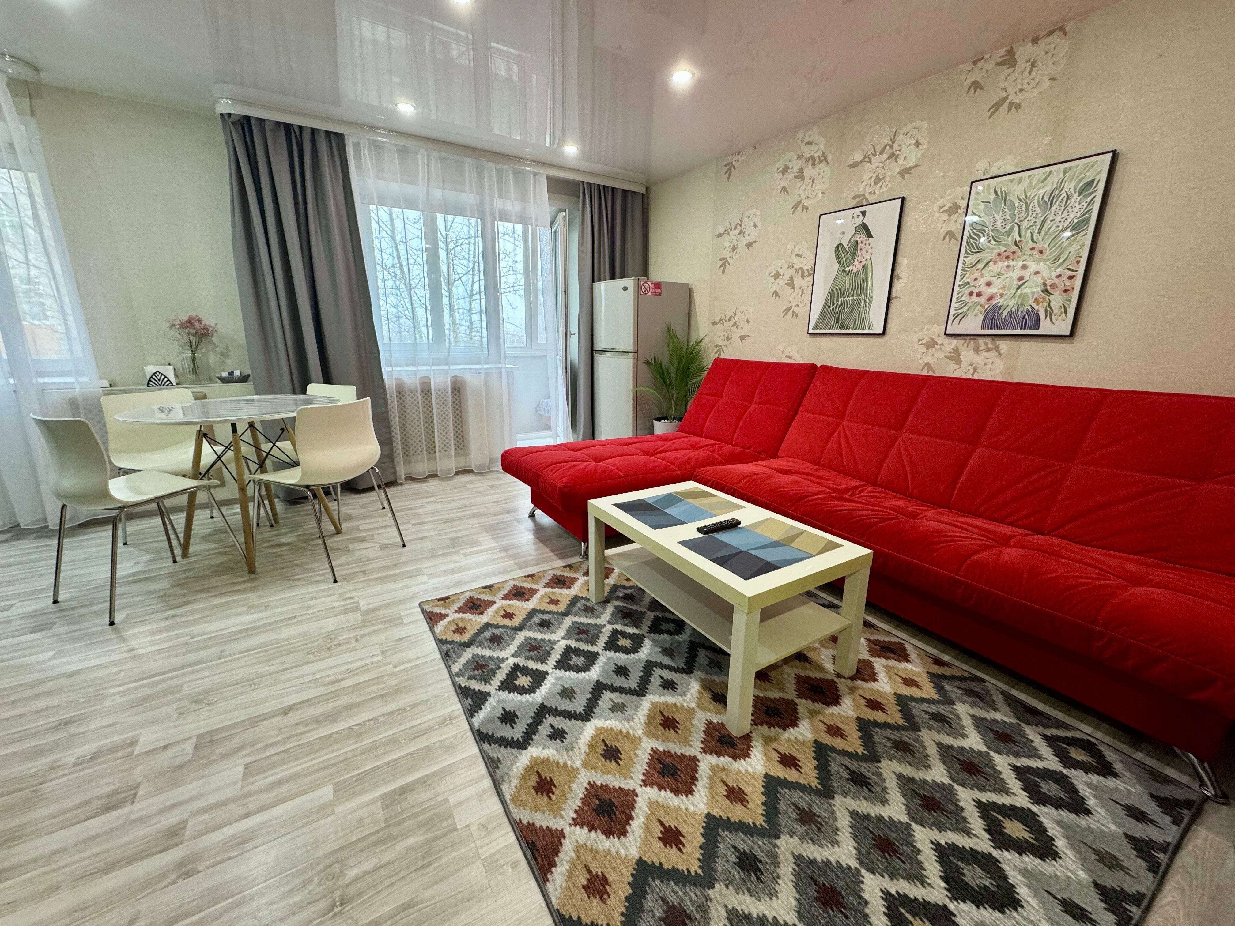 Двухкомнатная студия с красным диваном в центре города