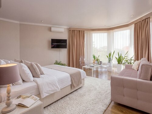 Номер «Люкс» с кроватью king-size и зоной отдыха у панорамного окна.