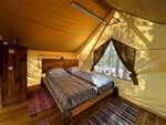 Сафари-тент на настиле с двуспальной кроватью, столом, мангалом в Гринвальд Парк Скандинавия