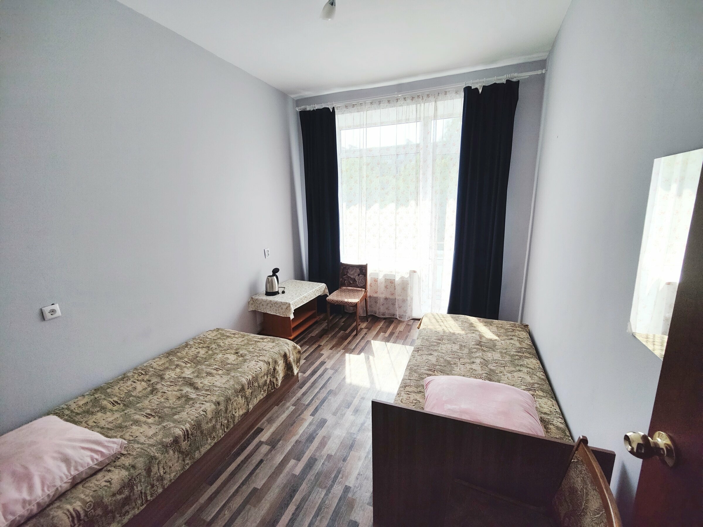 Односпальная кровать в общем номере для мужчин с общей ванной комнатой.