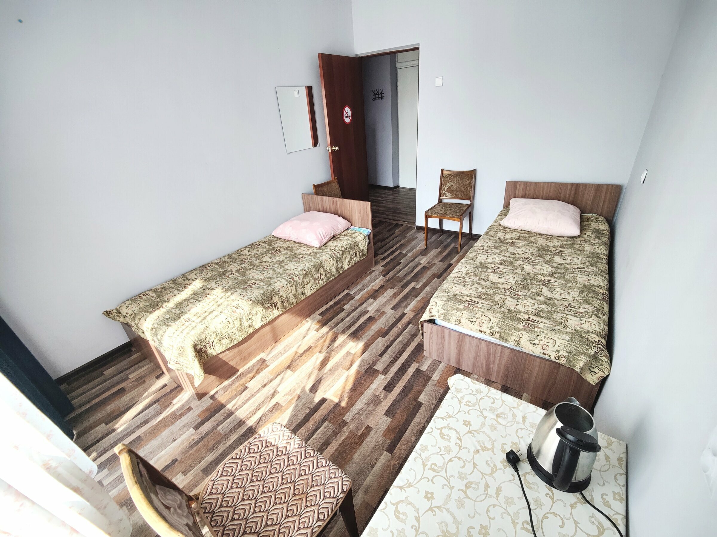 Односпальная кровать в общем номере для мужчин с общей ванной комнатой.