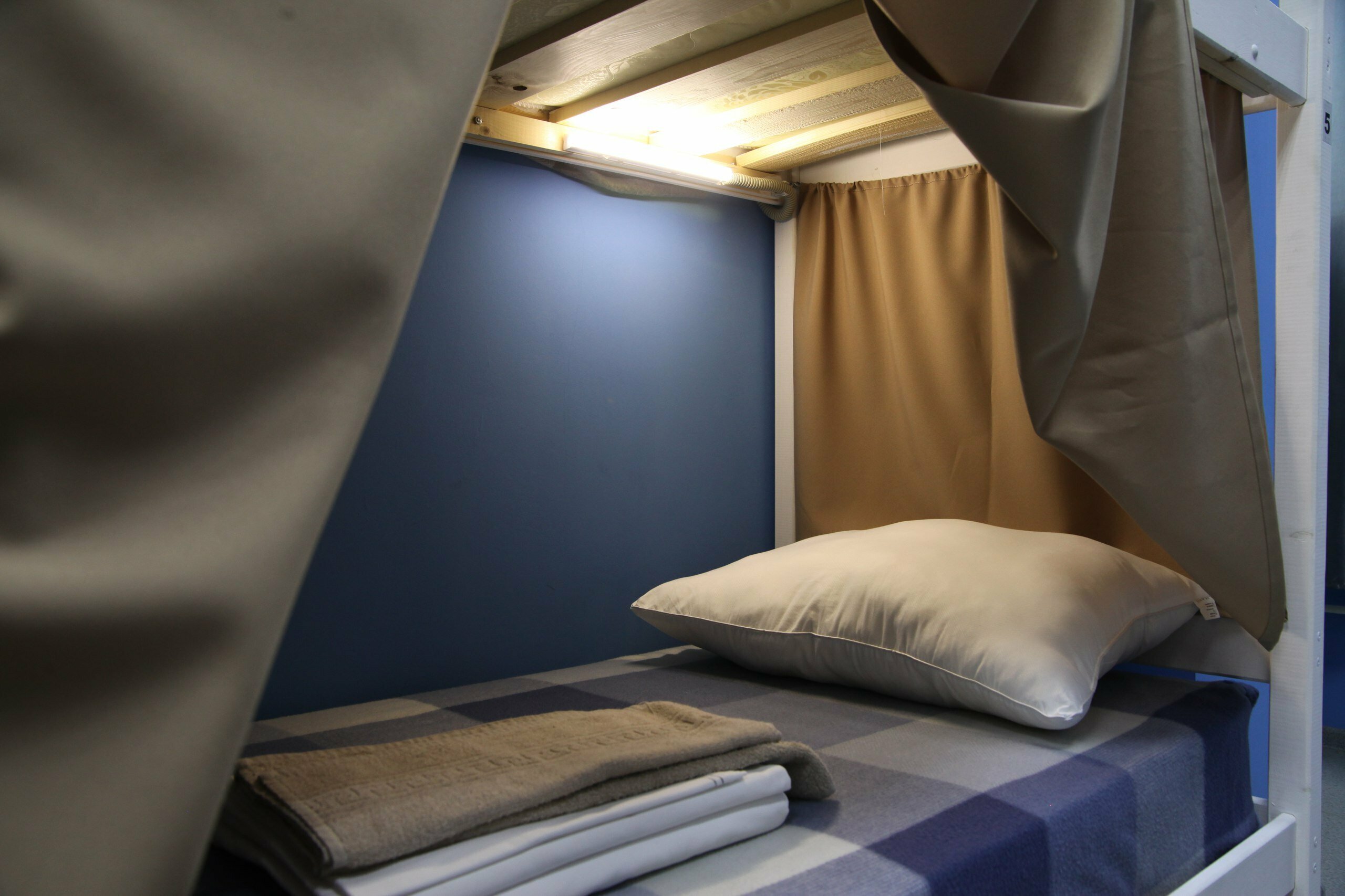 Спальное место на двухъярусной кровати в общем номере для мужчин и женщин