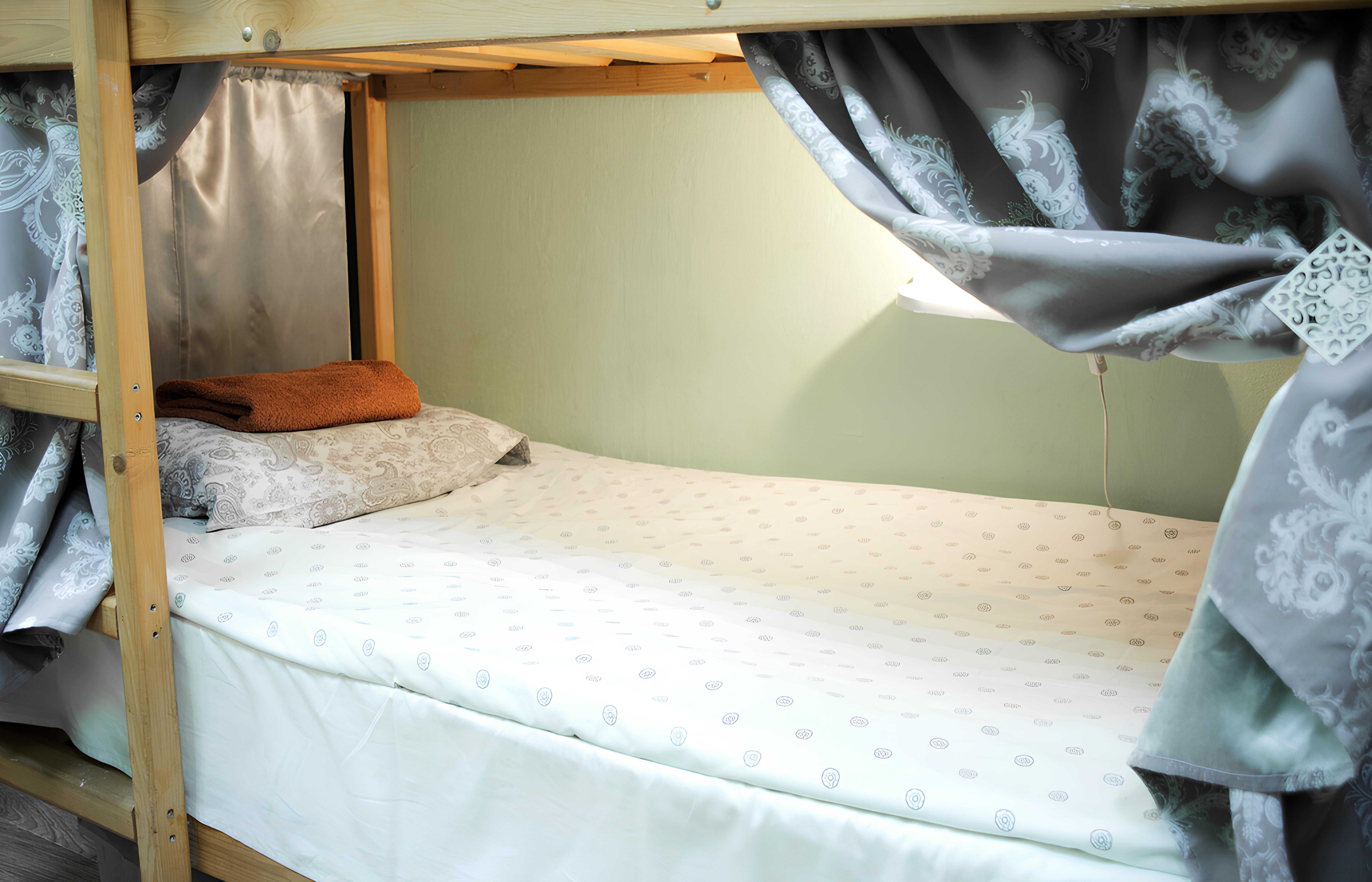 Спальное место на двухъярусной кровати в общем номере для мужчин и женщин