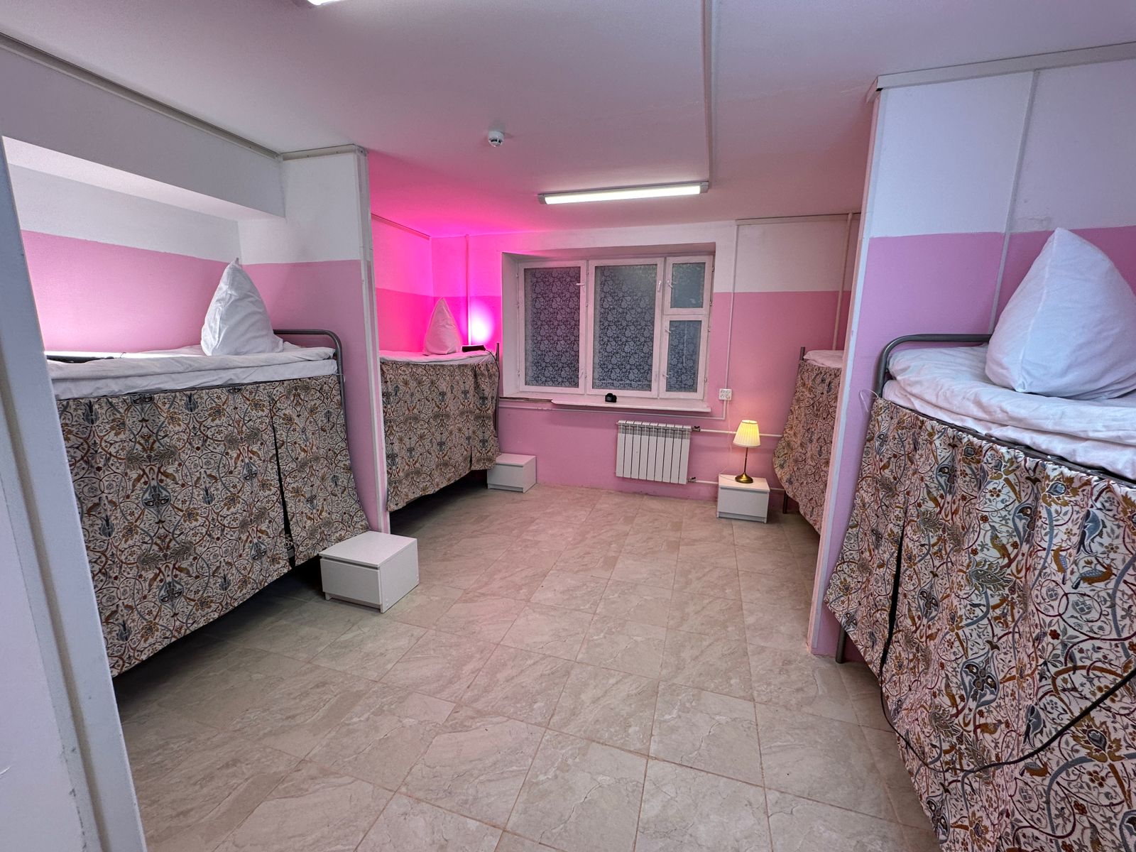 Односпальная кровать в общем номере для мужчин с общей ванной комнатой.