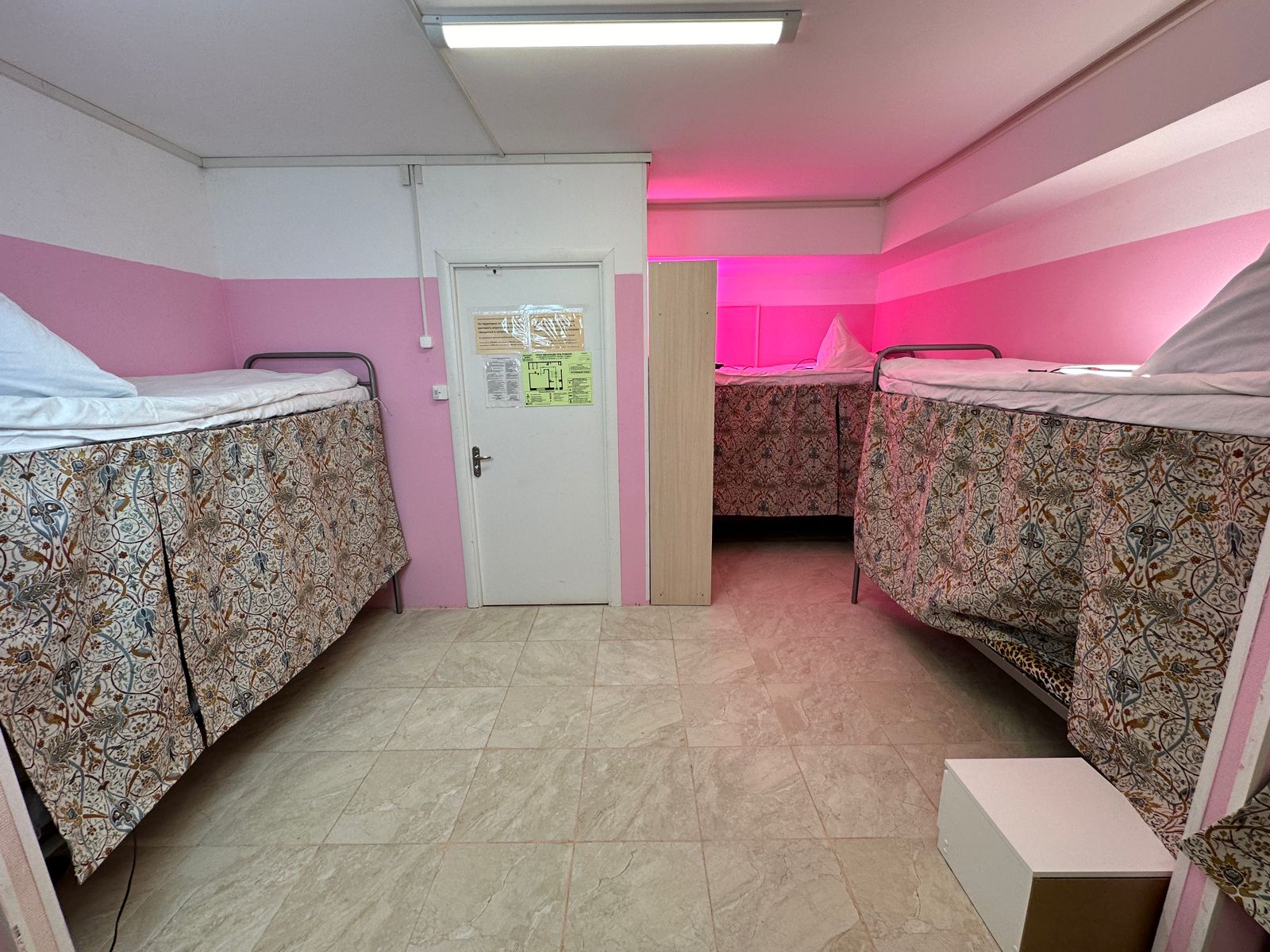 Односпальная кровать в общем номере для мужчин с общей ванной комнатой.