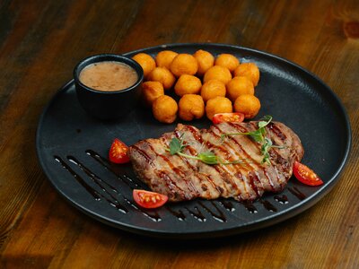 Стейк из cвинoй шеи с луковым соусом и крокетами
