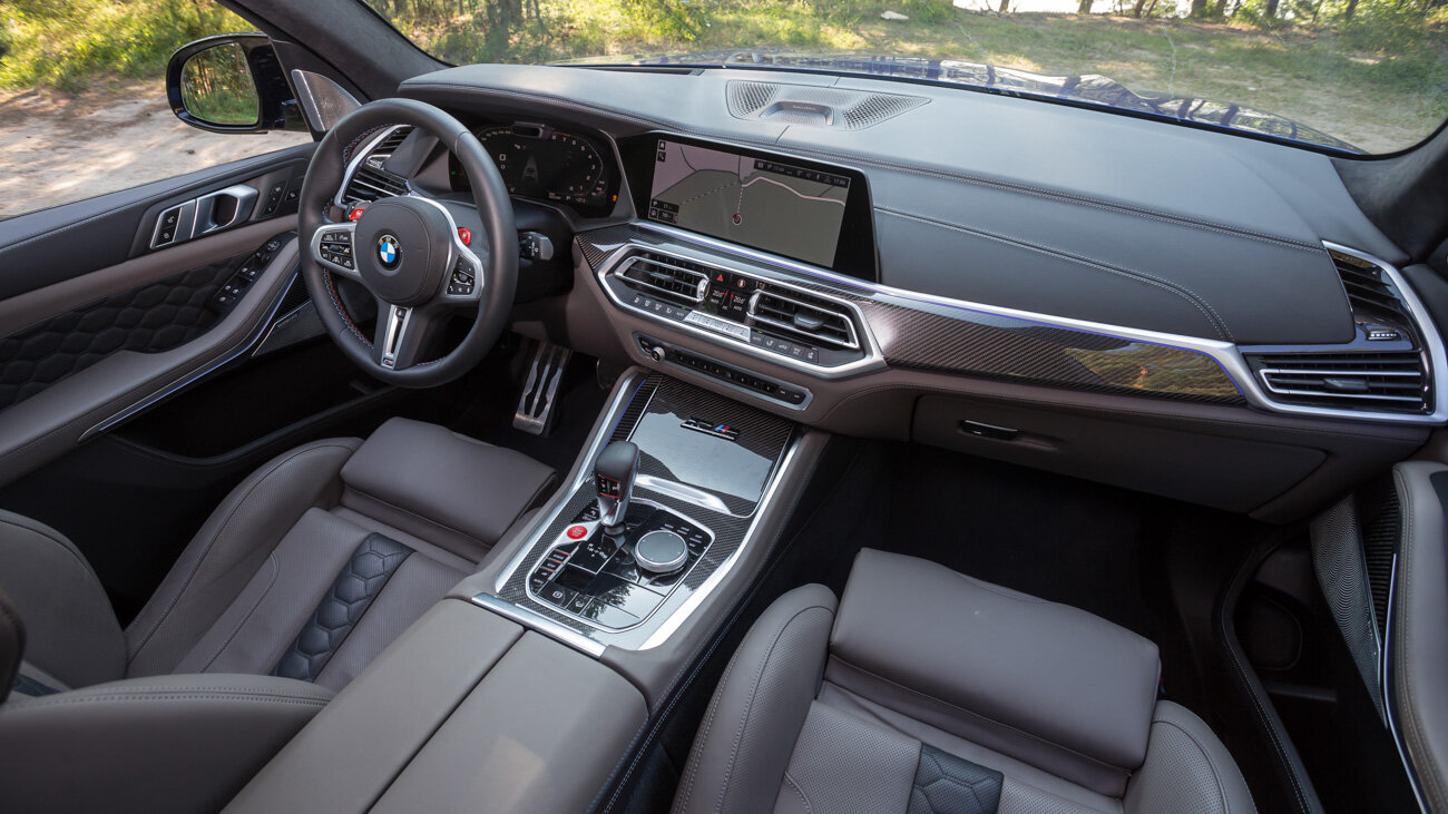 Интерьеры современных BMW — от «копейки» до X7 включительно — различаются только стоимостью материалов. Здесь они, без шуток, дорогие и приятные, а спортивная M-сущность подчёркивается карбоном и красными детальками