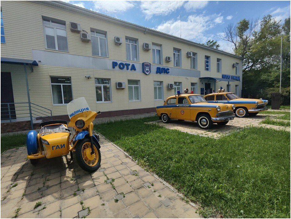 Рядом с двумя патрульными машинами стоит ещё один экспонат — мотоцикл.