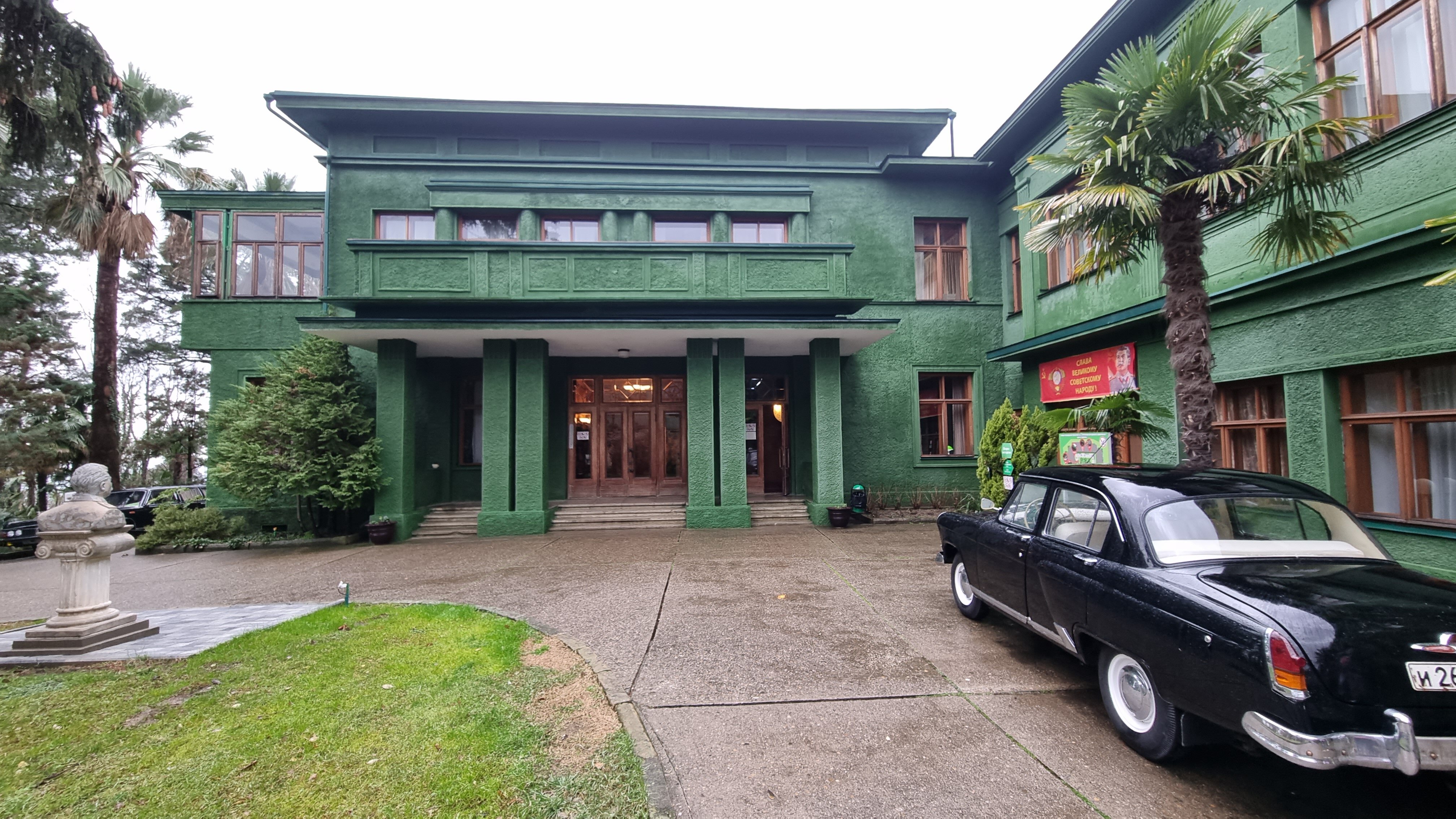 Боковой вид на здание с колоннами и террасой